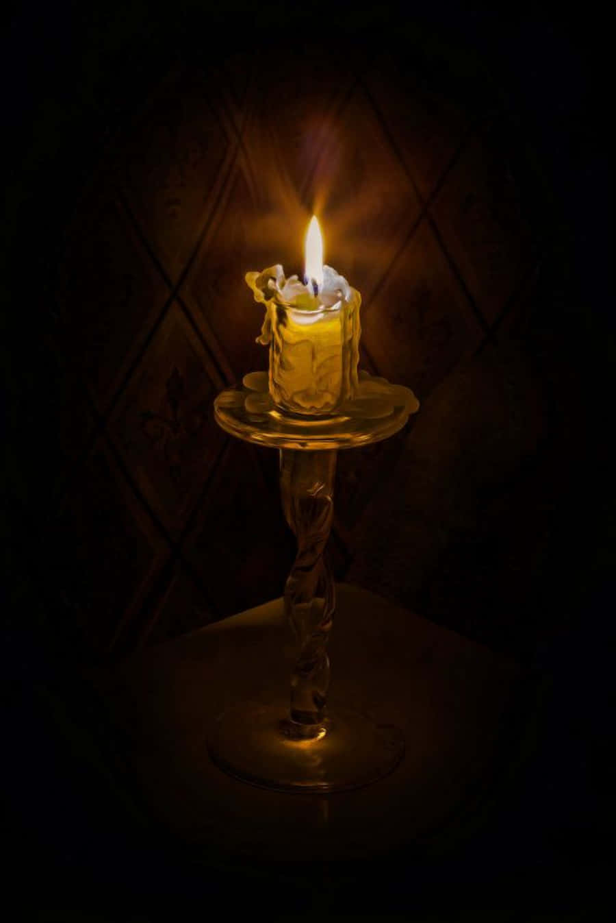 A Candle Is Lit In A Glass Cup