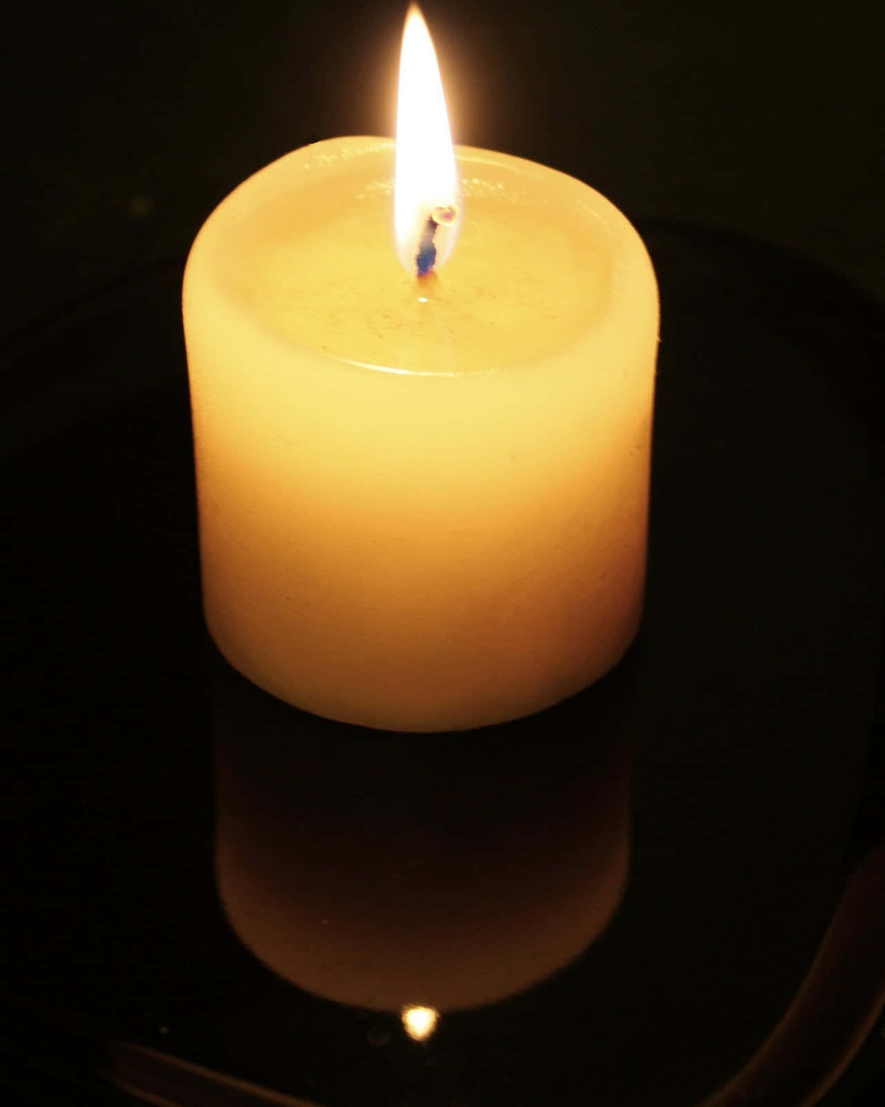 A single candle burning brightly in the dark