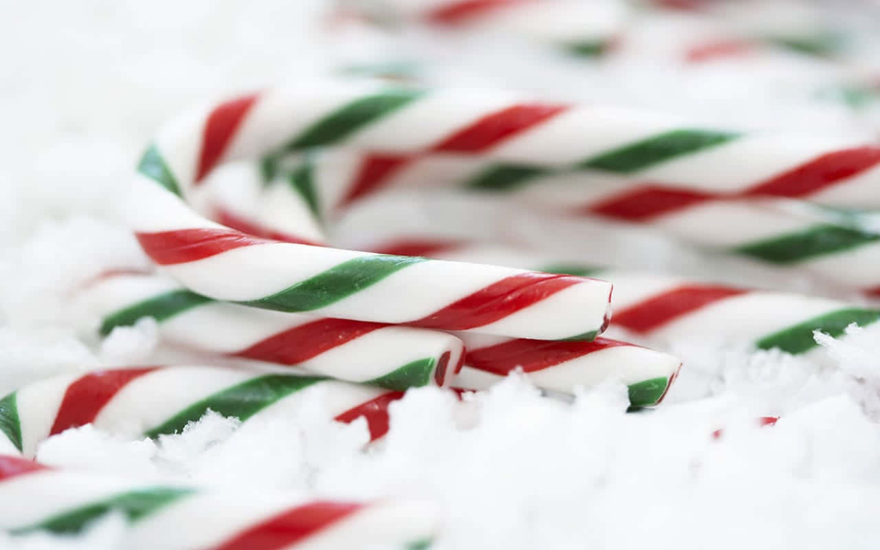 Candy Canes On A Snow Covered Surface Wallpaper