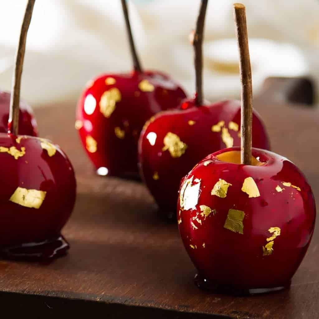 Colorful and delicious candy apples on wooden table Wallpaper