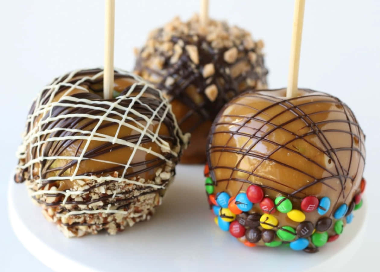 Delectable Candy Apples on a Rustic Wooden Table Wallpaper