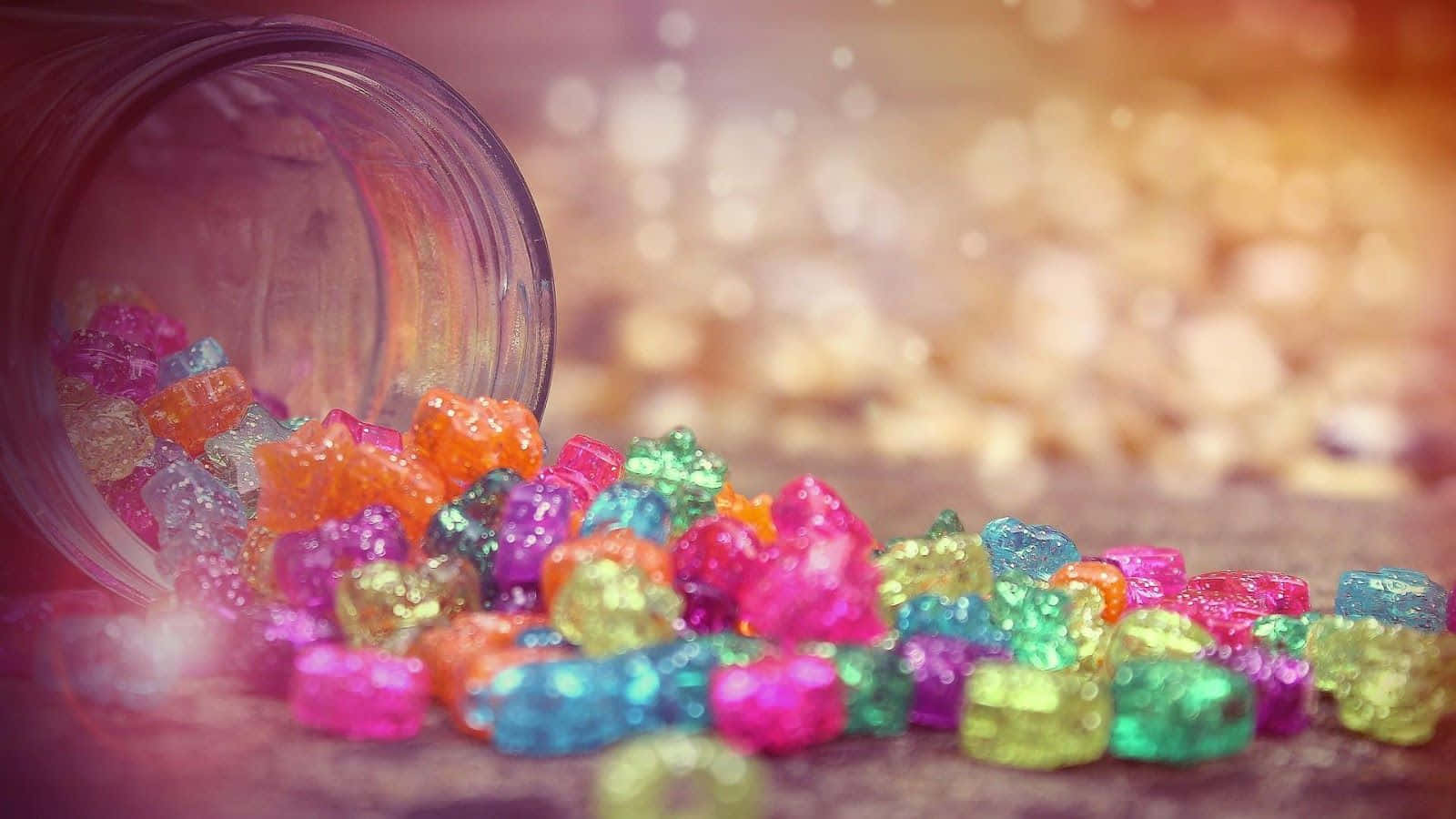 A Jar Of Colorful Candy Sitting On The Ground
