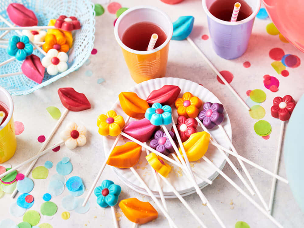 A Table With Colorful Cupcakes And A Plate Of Candy