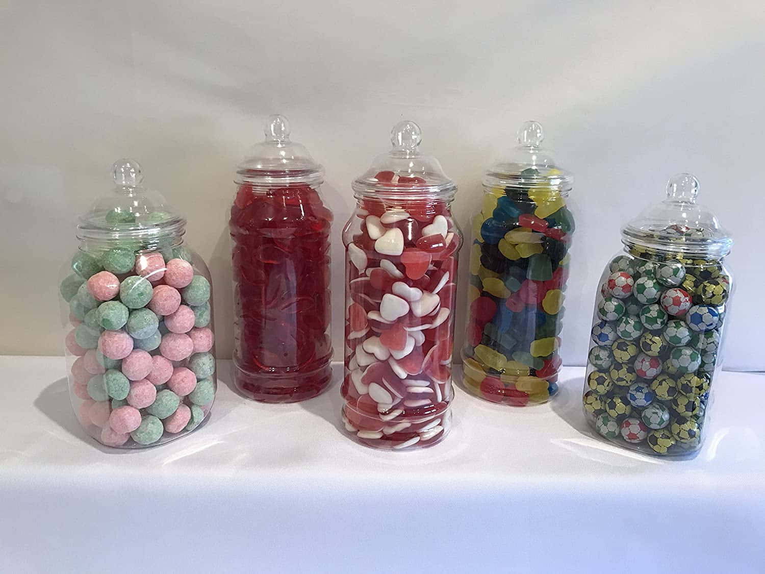 A Group Of Candy Jars With Candy Inside
