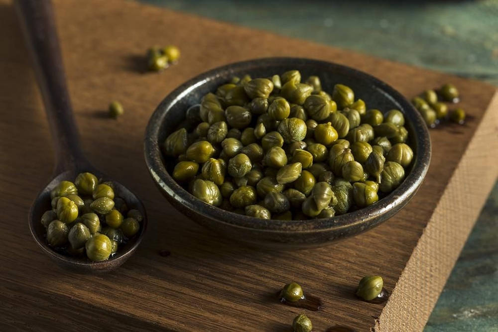 Fresh Capers in a Dark Soup Bowl Wallpaper