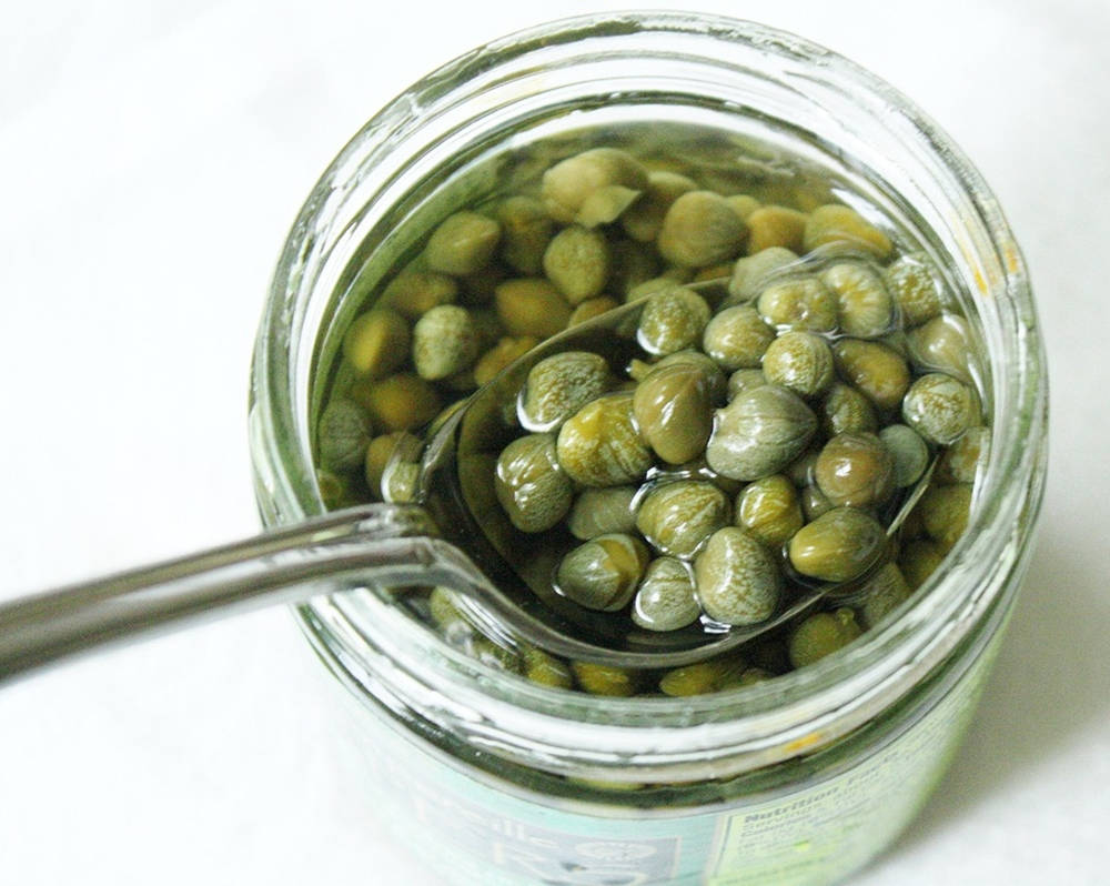 Capers Scooped From Glass Jar Wallpaper