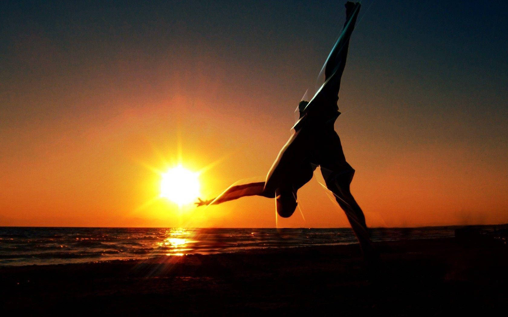 Capoeira Fighter Doing A Flip At Sunset Wallpaper
