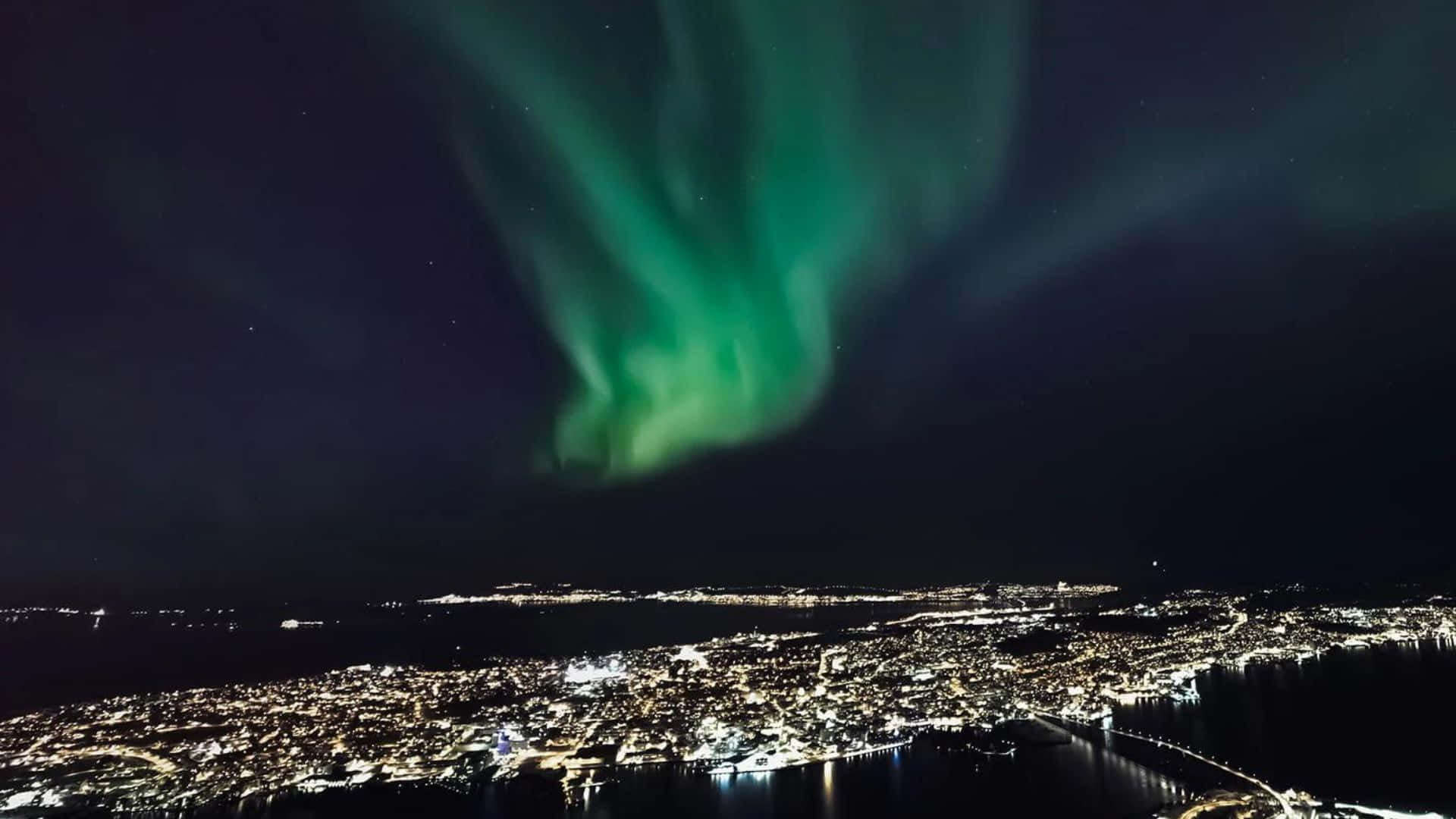 Caption: Breathtaking View Of Tromsø, Norway Nestled Beneath Snow-capped Mountains. Wallpaper