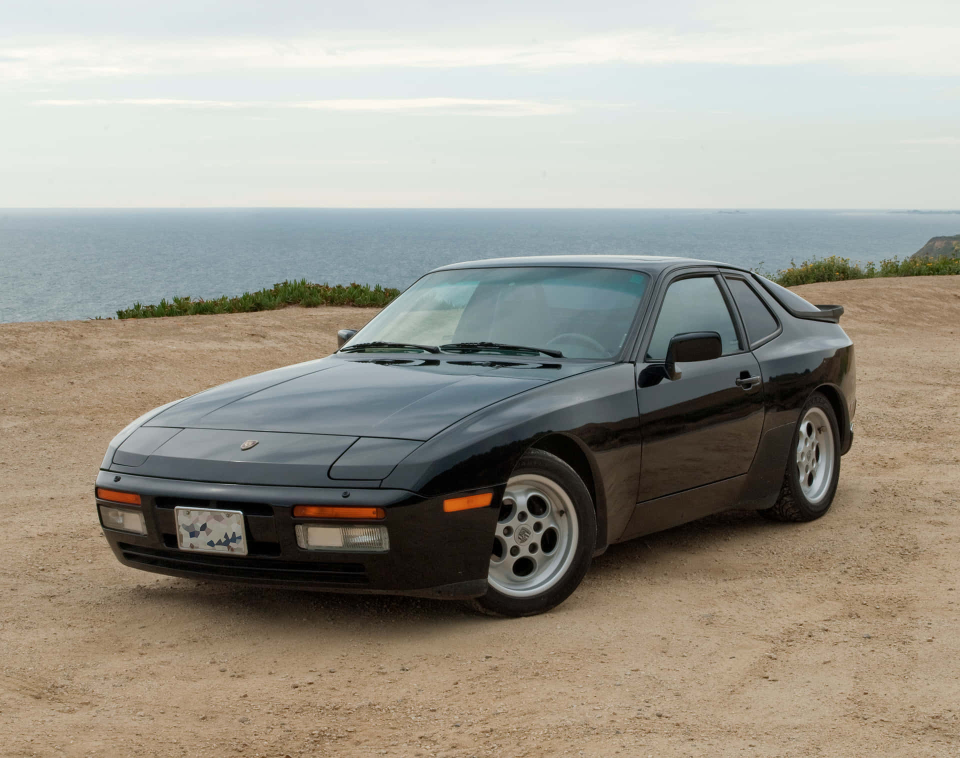 Caption: Classic Red Porsche 944 Under The Open Sky Wallpaper