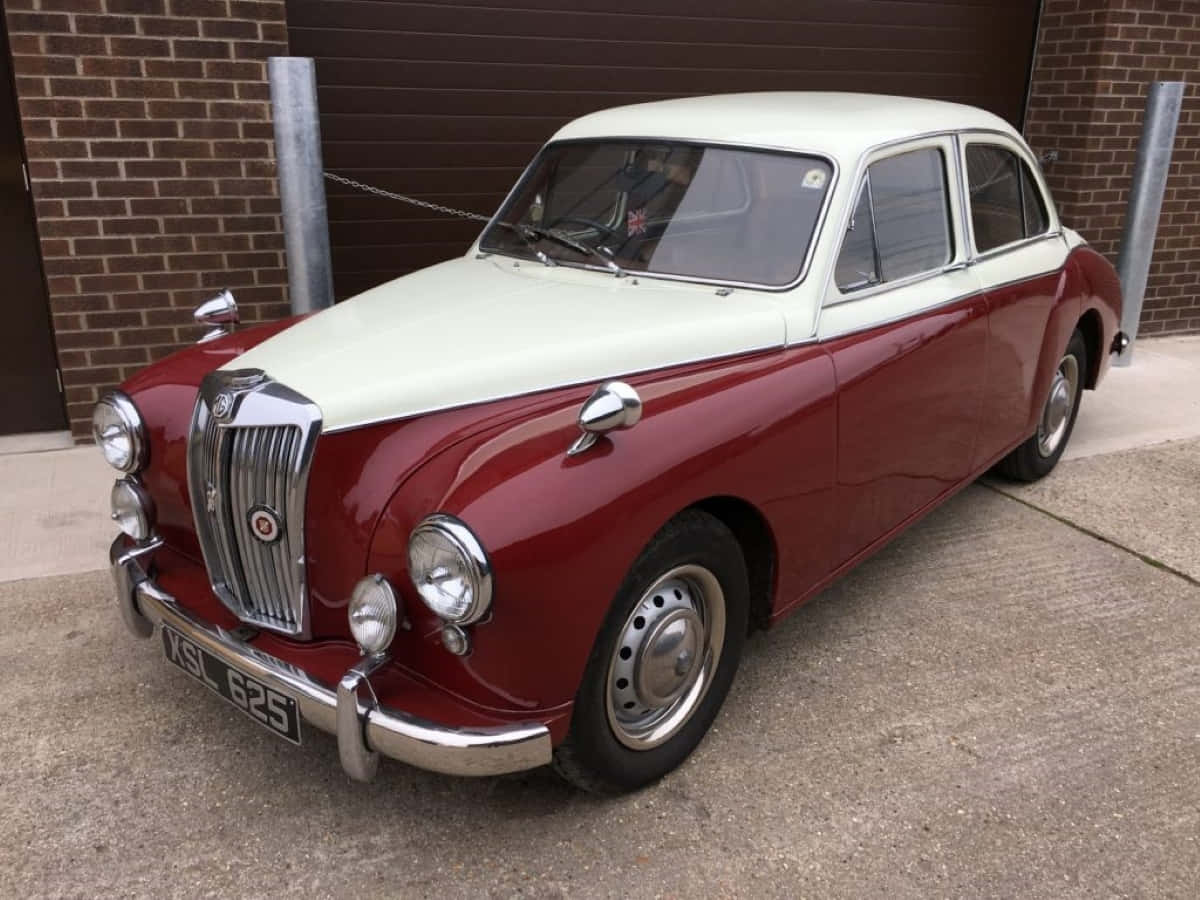 Caption: Classically Styled Mg Magnette Sedan Against A Serene Landscape Wallpaper