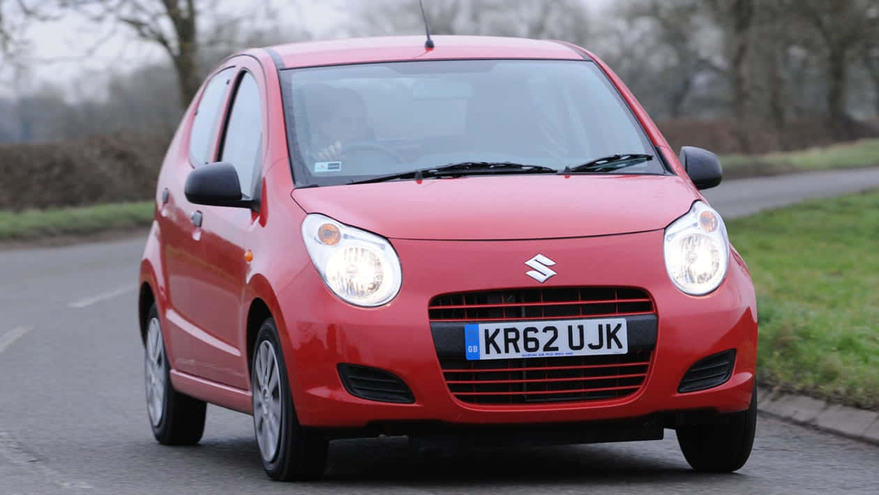 Caption: Dynamic Suzuki Alto In Vibrant Red Wallpaper