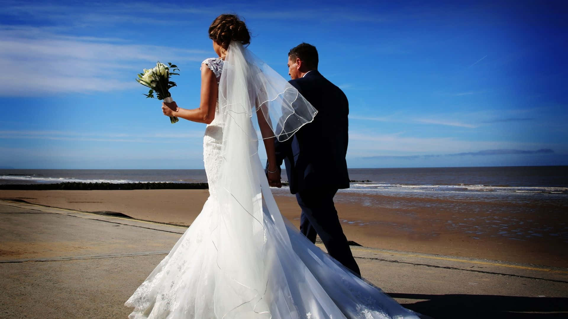 Caption: Eternal Love By The Shoreline: A Beautiful Beach Wedding Moment Wallpaper