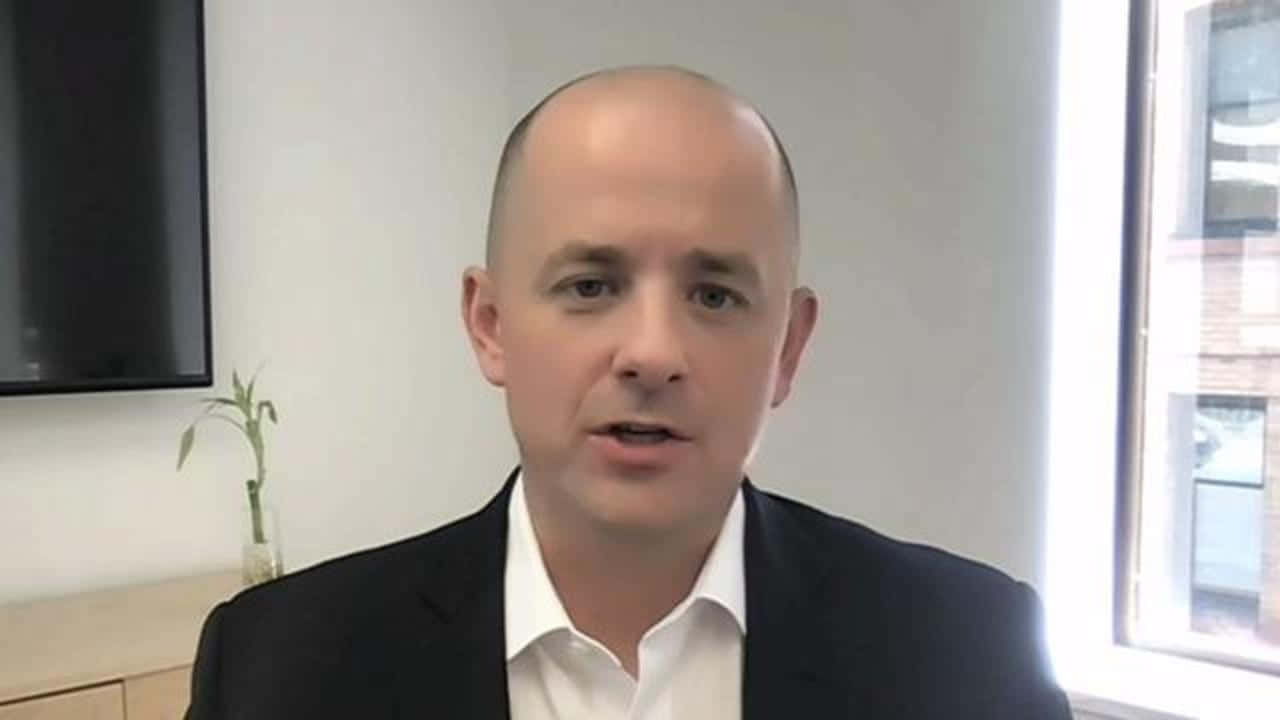 Caption: Evan Mcmullin Standing In Front Of An American Flag Wallpaper
