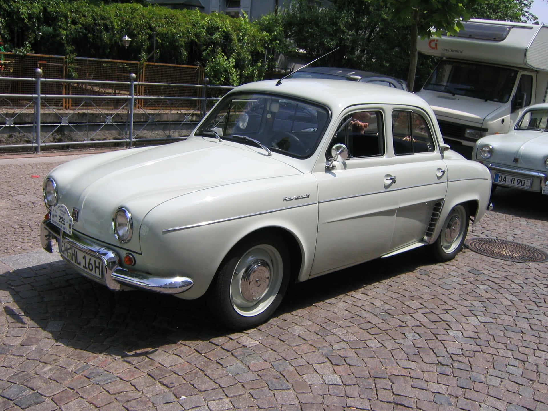 Caption: Iconic Renault Dauphine Riding In An Urban Landscape Wallpaper