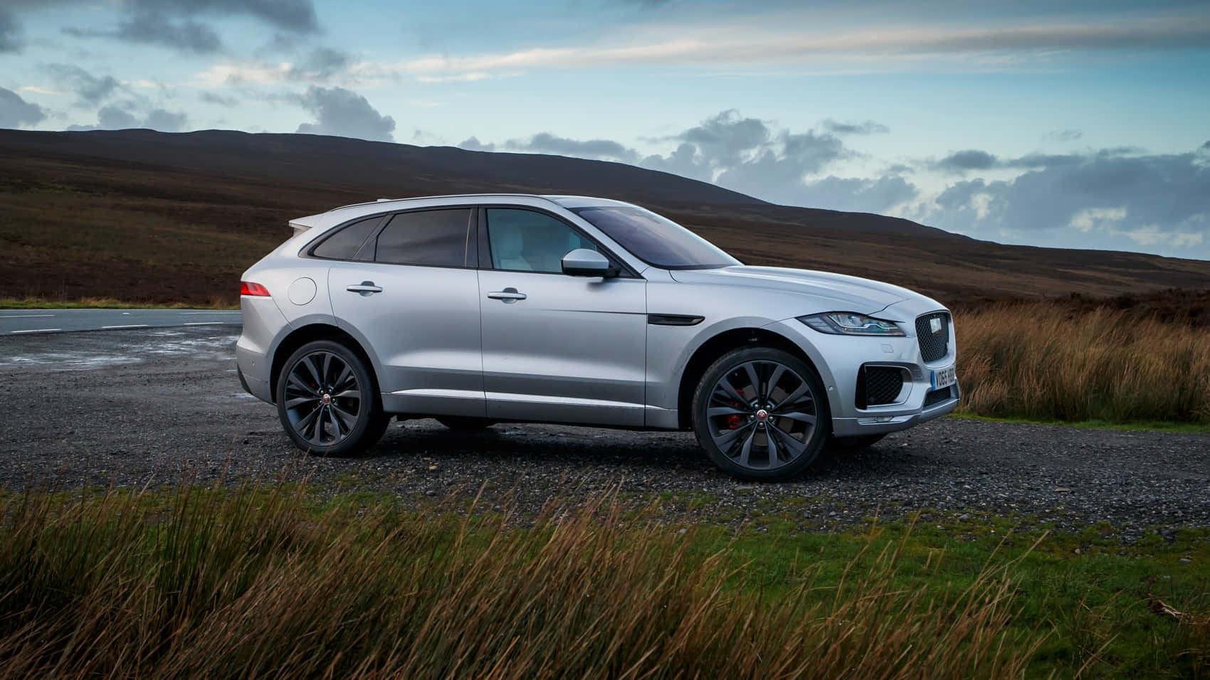 Caption: Majestic Jaguar F-pace Unleashed On A Country Road Wallpaper