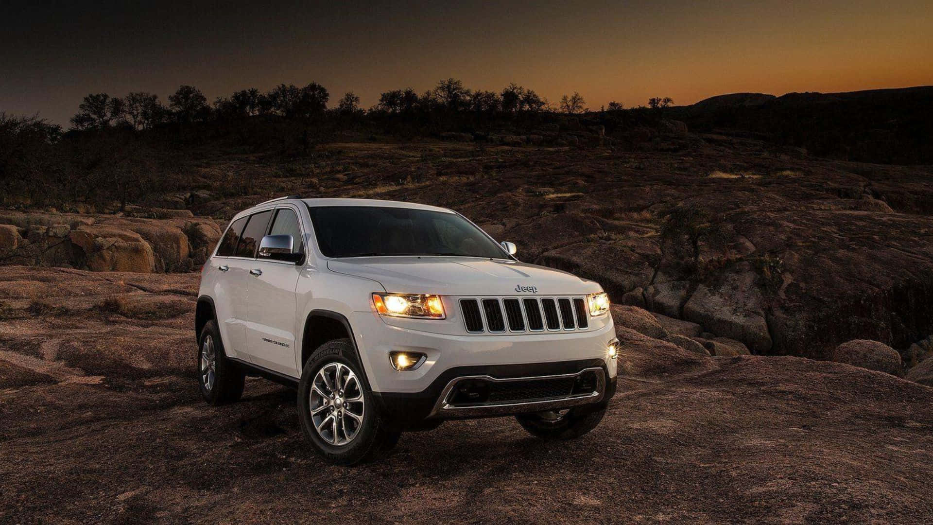 Caption: Majestic Jeep Grand Cherokee Conquering A Rocky Terrain. Wallpaper