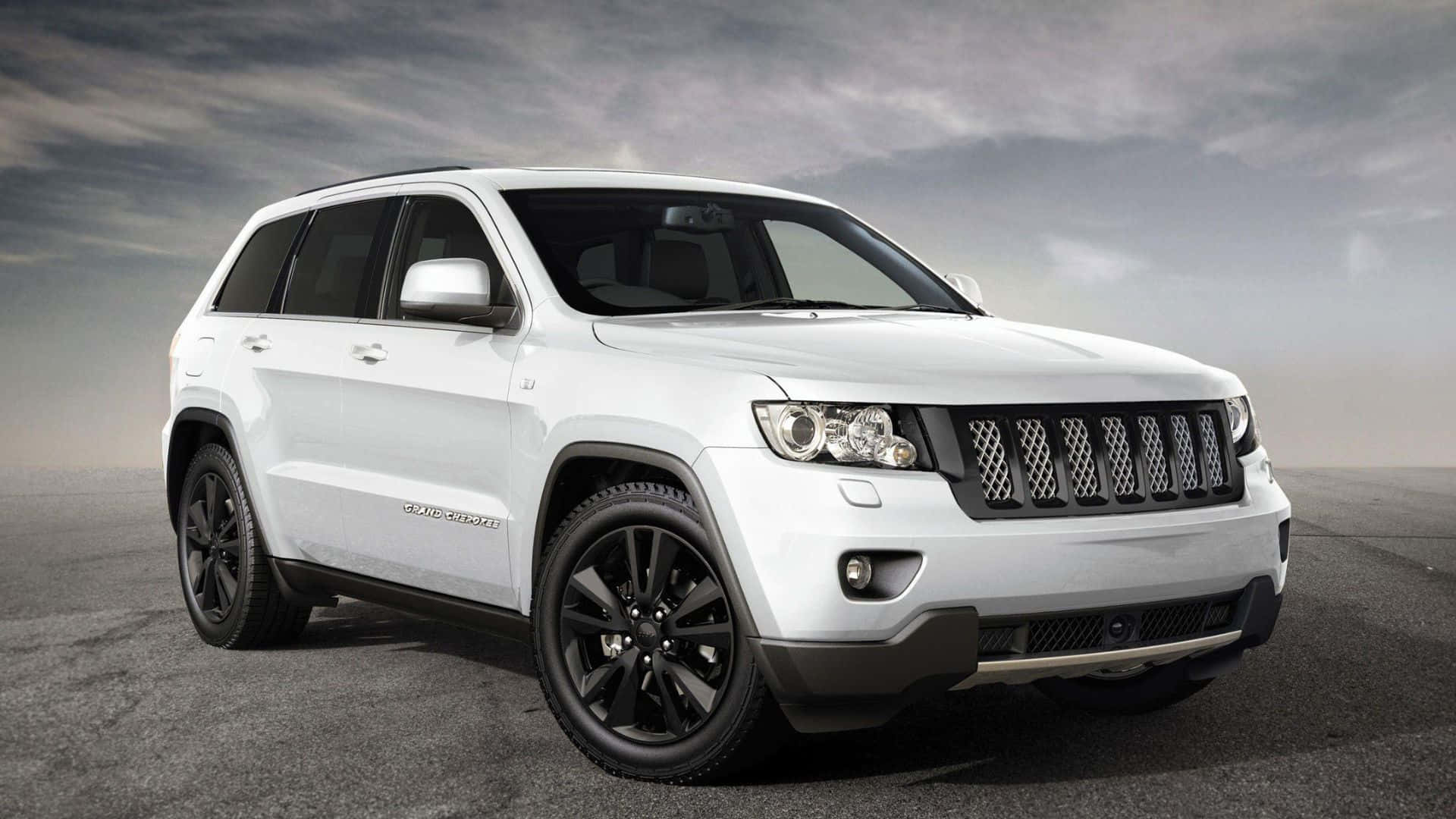 Caption: Refined Ruggedness: Jeep Grand Cherokee In Wilderness Wallpaper
