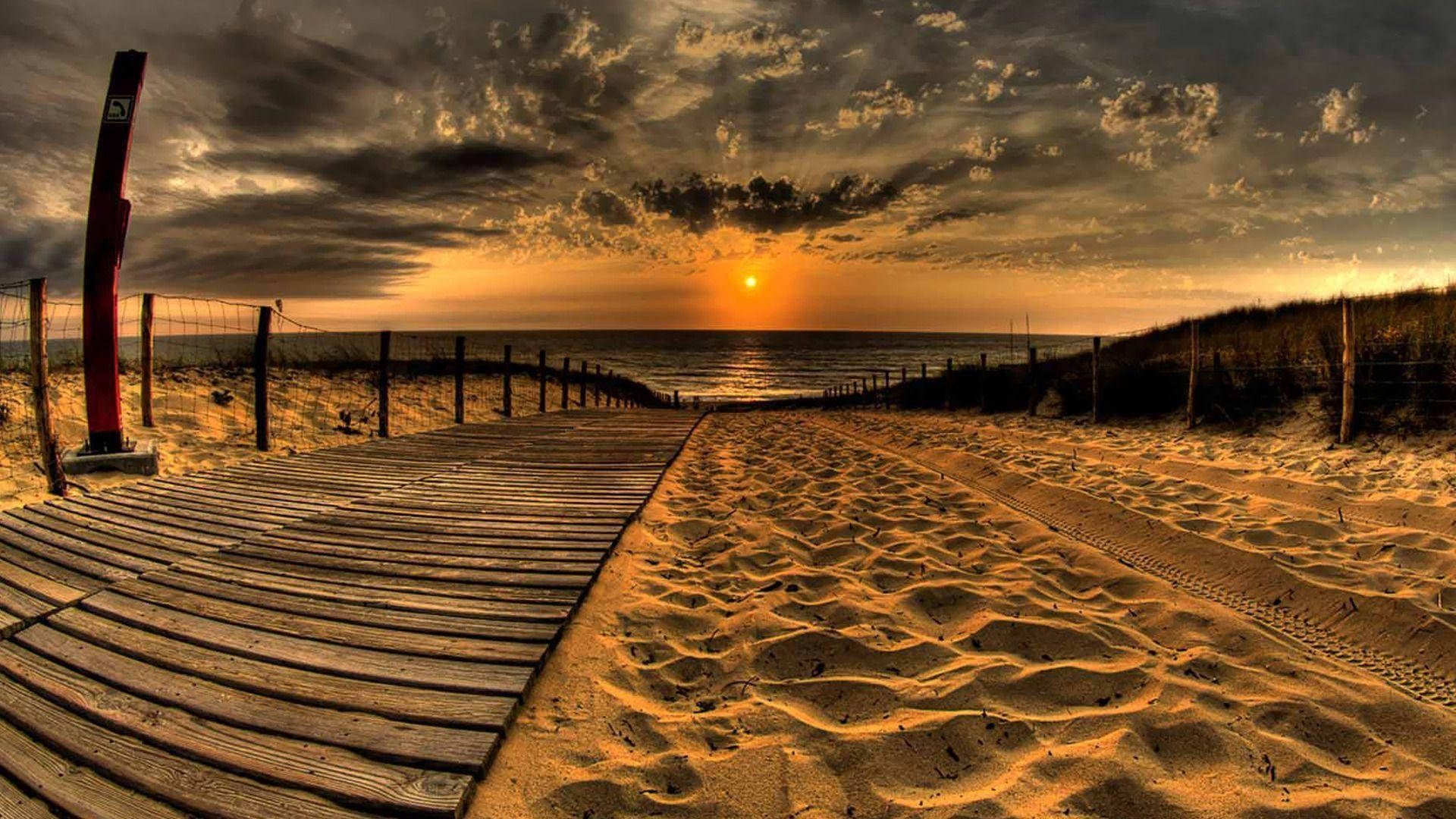 Caption: Serene Sunset At The Beach Wallpaper