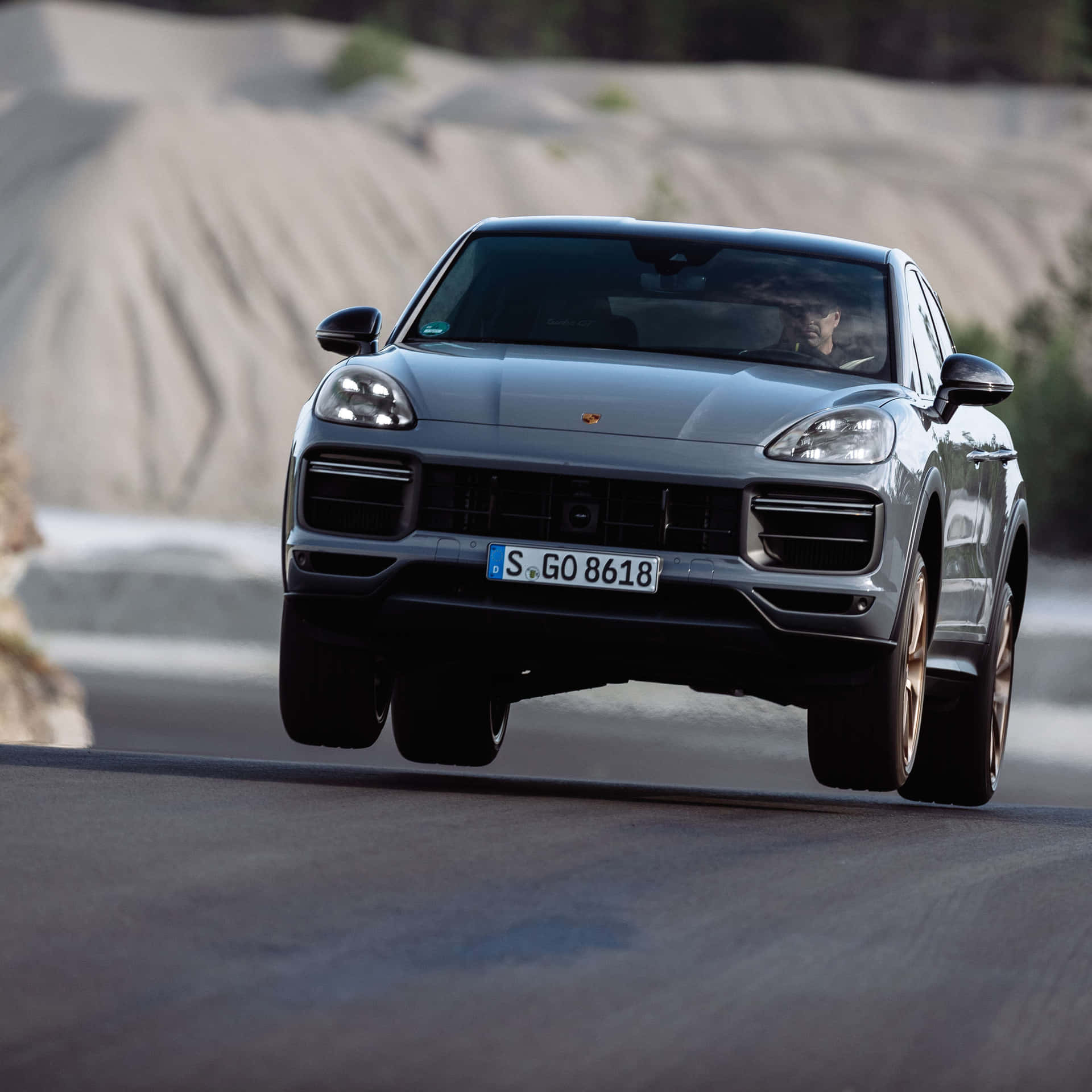 Caption: Sleek 2023 Porsche Cayenne Turbo Cruising On An Open Road. Wallpaper