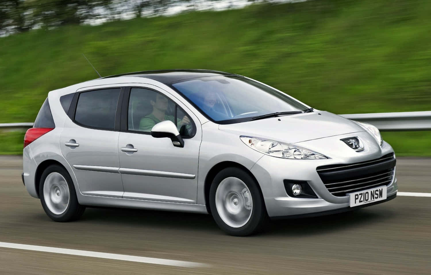 Caption: Sleek Peugeot 207 Gliding On Country Road Wallpaper