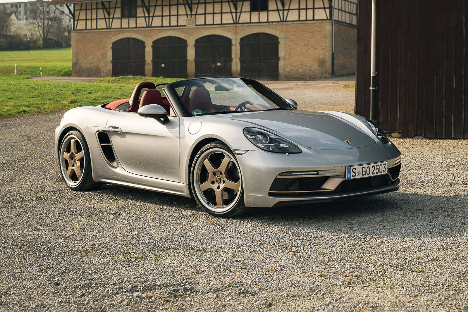 Caption: Sleek Porsche Boxster Gliding Through Urban Landscape Wallpaper