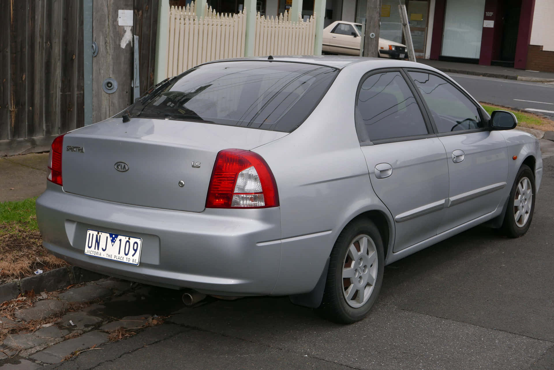 Caption: Sleek Silver Kia Spectra Parked On The Street Wallpaper