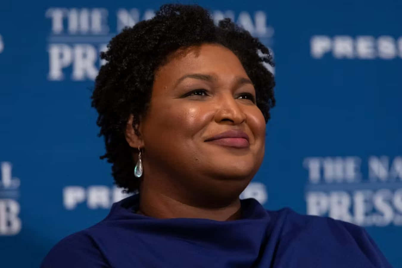 Caption: Stacey Abrams In Thoughtful Discussion Wallpaper