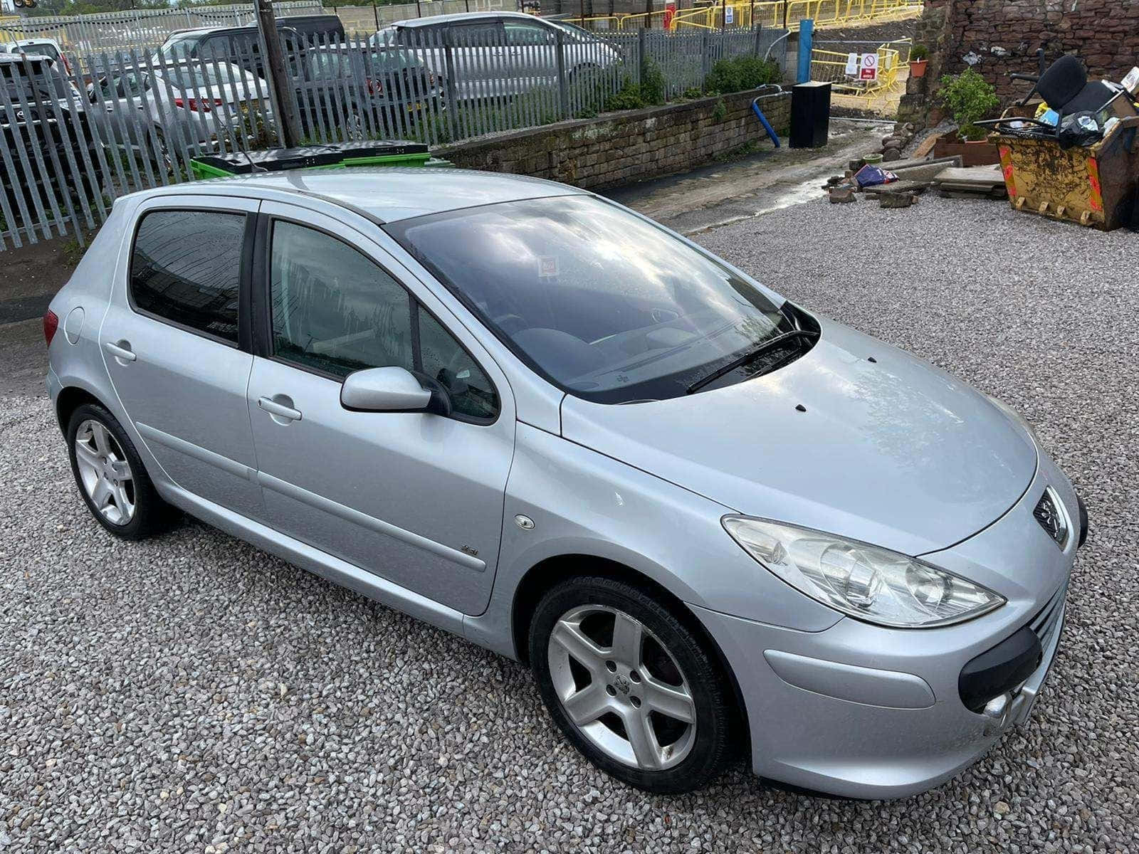Caption: Stylish Peugeot 307 Compact Hatchback On A Picturesque Road Wallpaper