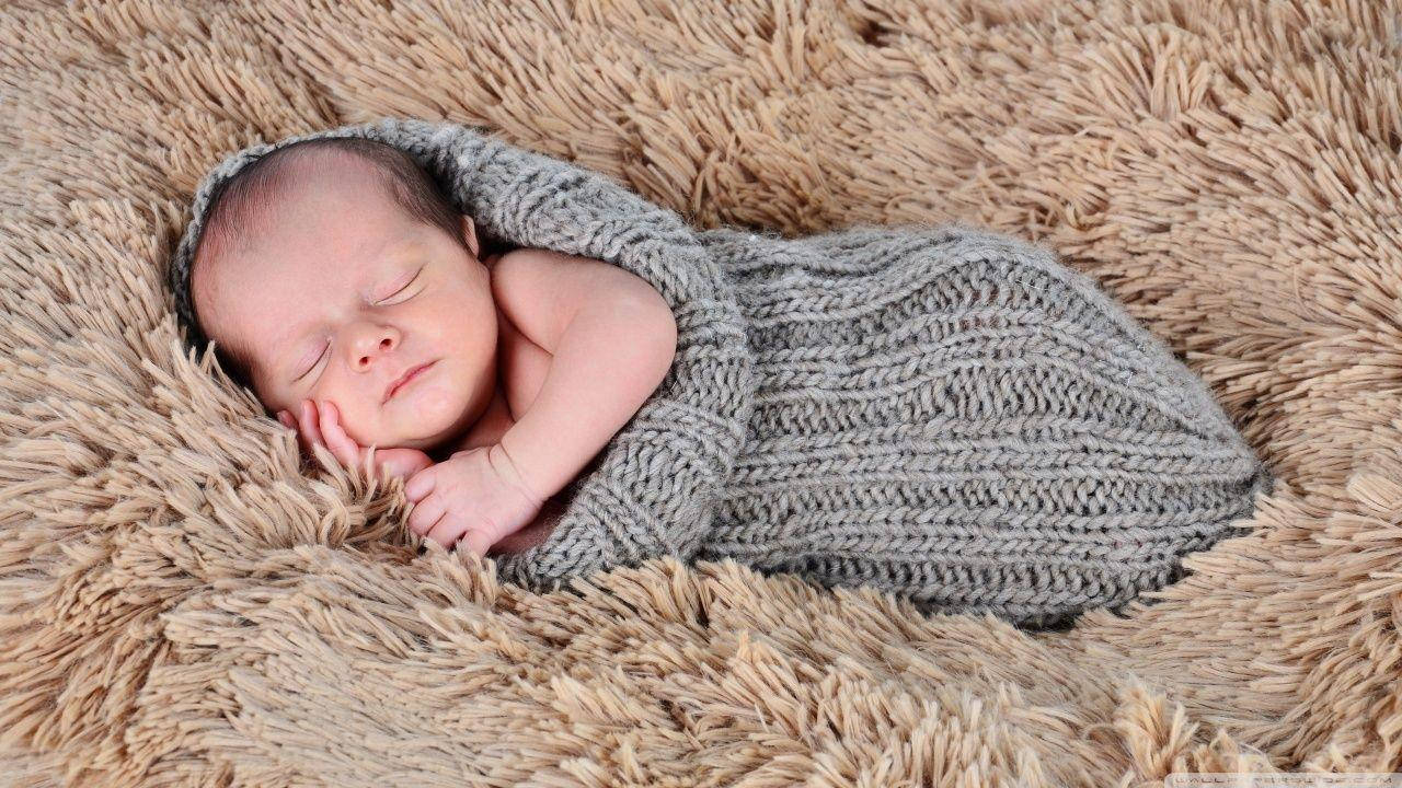 Caption: Sweet Dreams: Newborn Baby Sleeping Peacefully Wallpaper