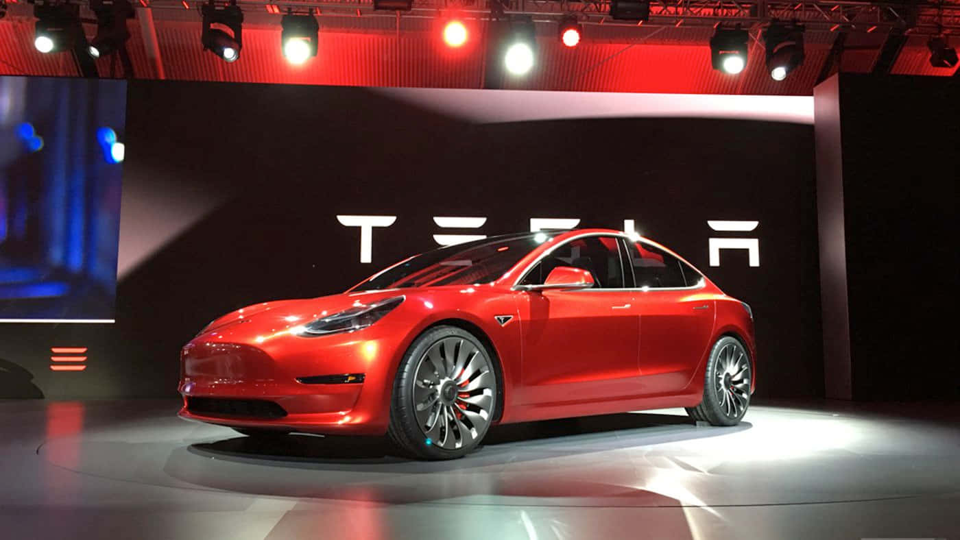 Caption: The Innovative Tesla Model 3 Charging Under Streetlight Wallpaper
