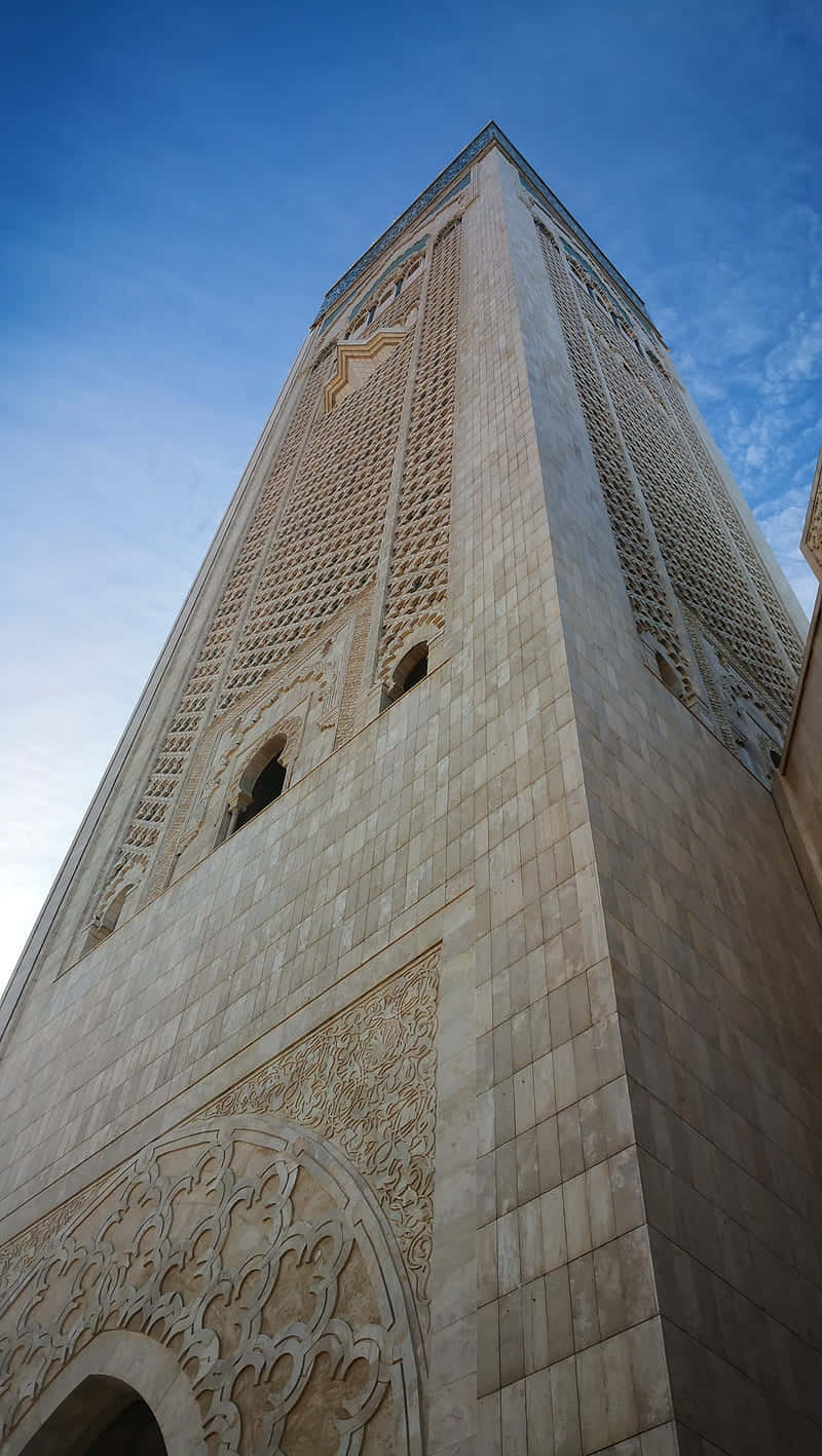 Caption: The Stunning Architecture Of Hassan Ii Mosque During A Serene Sunset. Wallpaper
