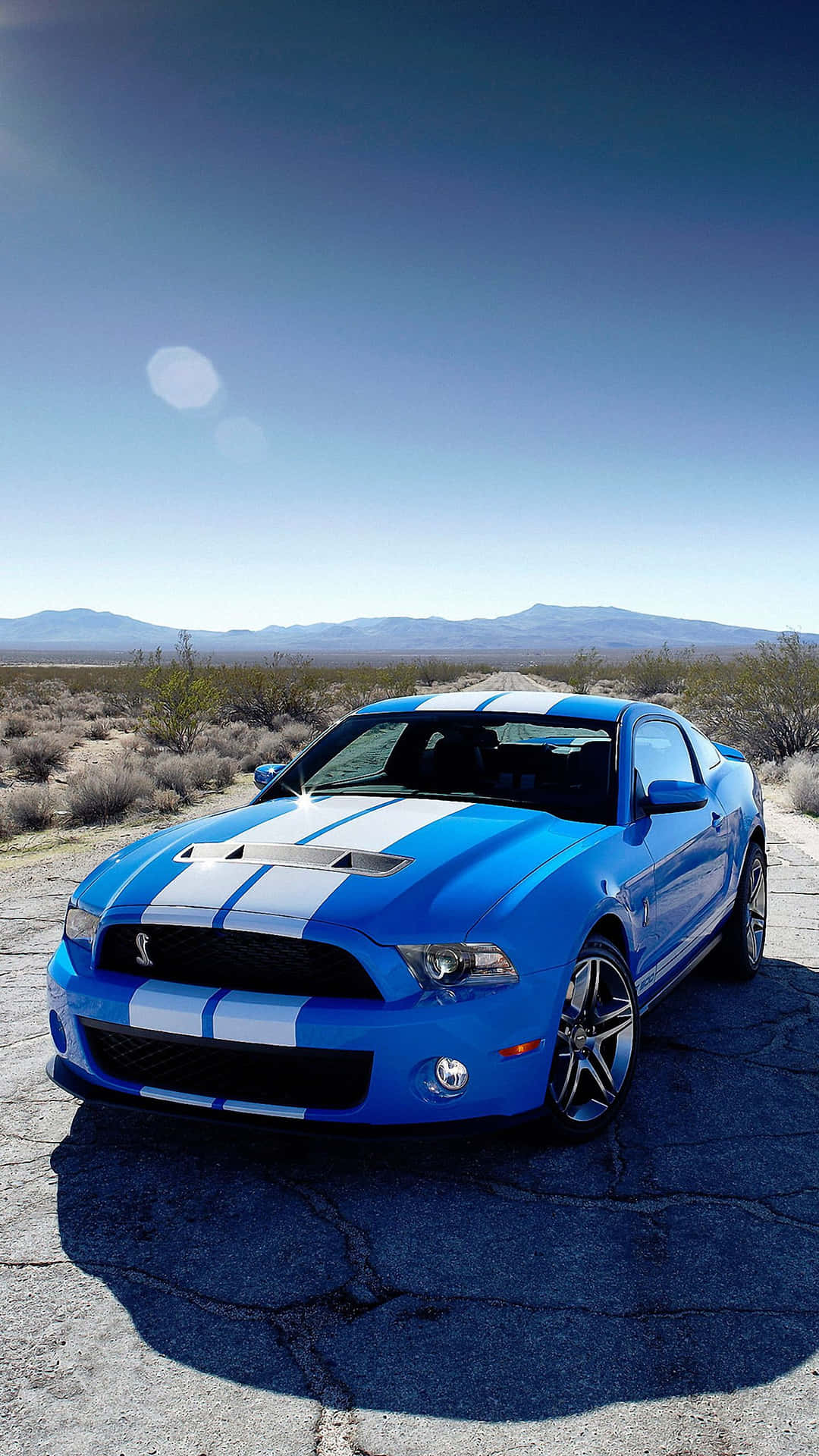 A Blue Ford Mustang Gt Parked In The Desert Wallpaper
