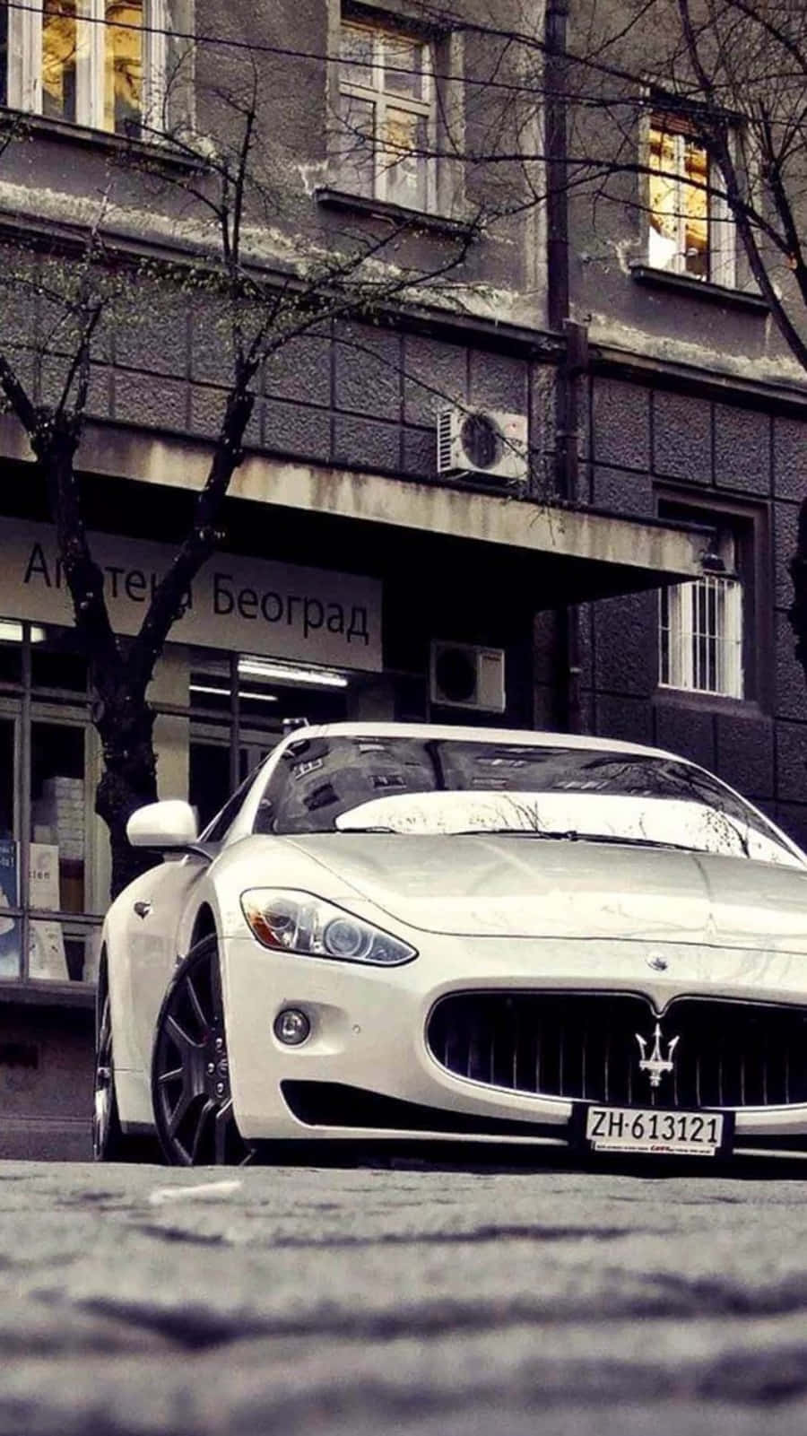 A White Maserati Parked On The Street Wallpaper