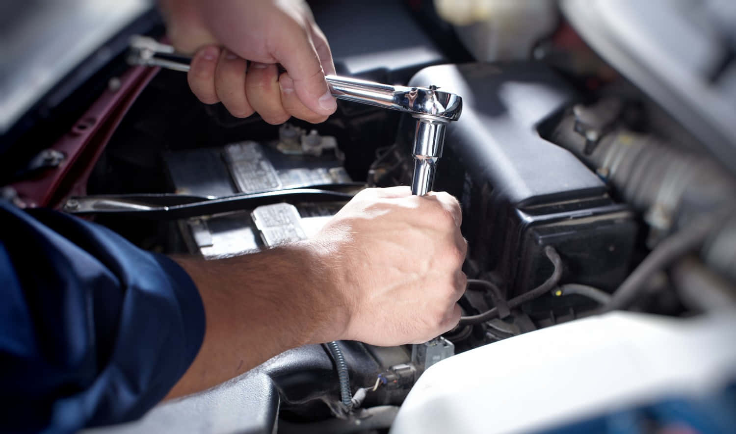 Professional Mechanic Repairing a Car in a Garage Wallpaper