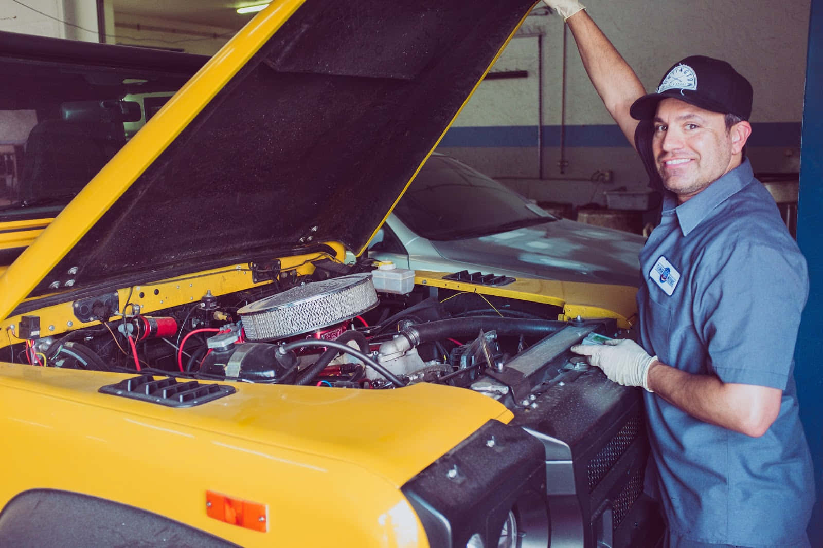 Professional Mechanic Fixing a Car in an Auto Repair Shop Wallpaper