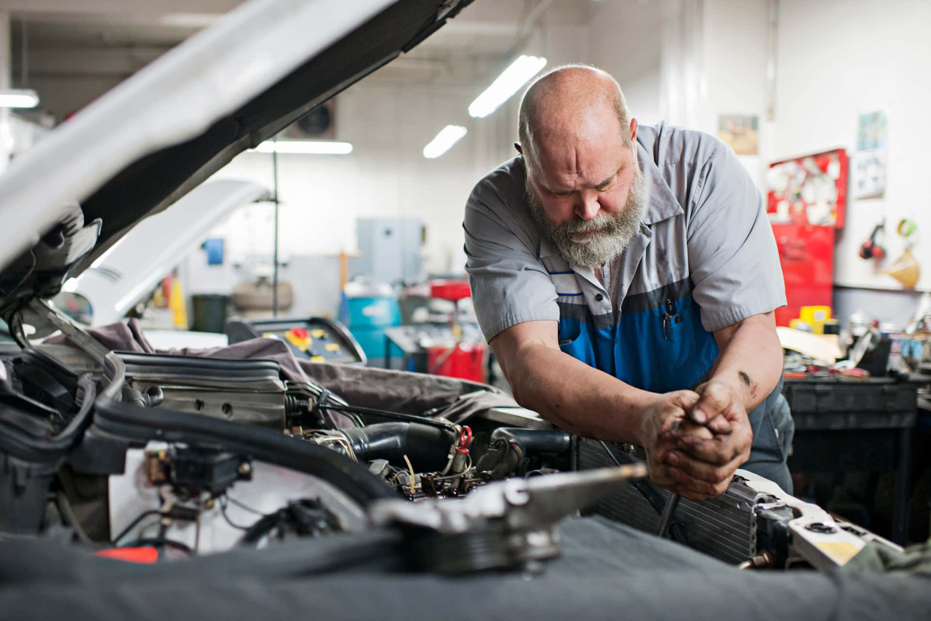 Professional mechanic repairing a car in automobile service center Wallpaper