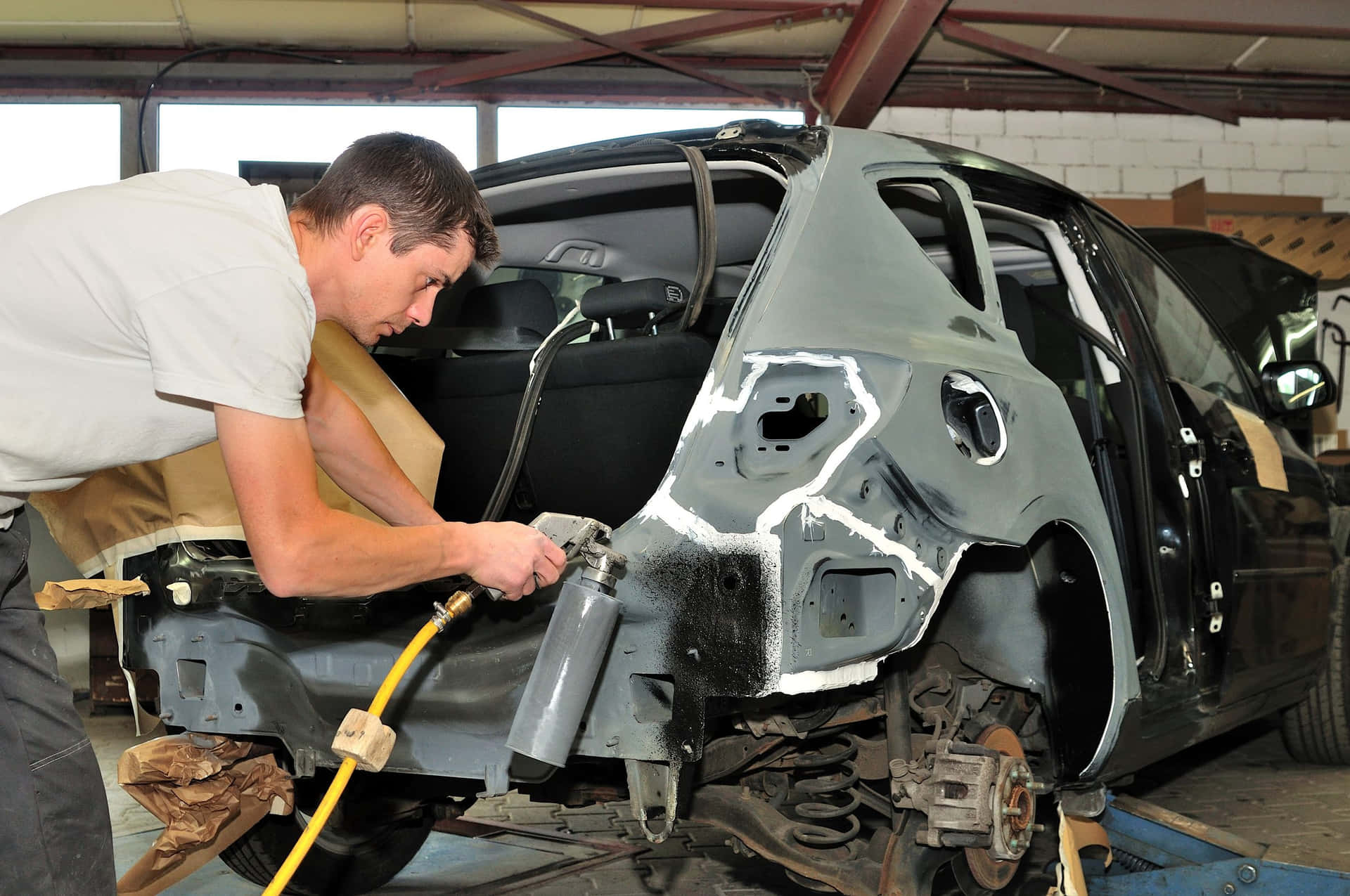 Professional mechanic repairing car at an auto repair shop Wallpaper