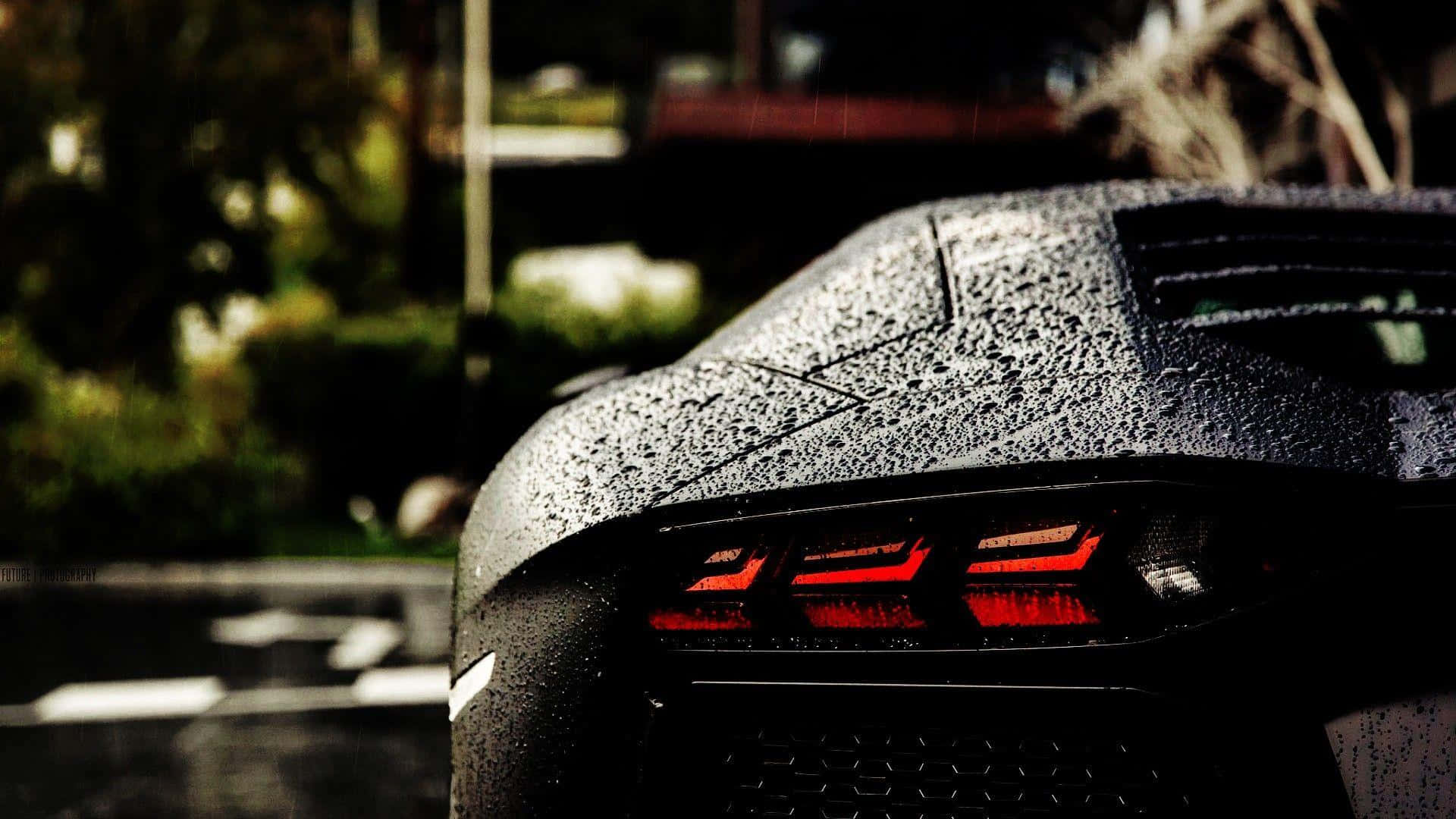 A Black Sports Car Is Parked In The Rain