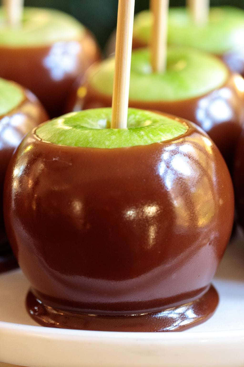 Delicious Caramel Apples with Nuts and Candy Toppings Wallpaper