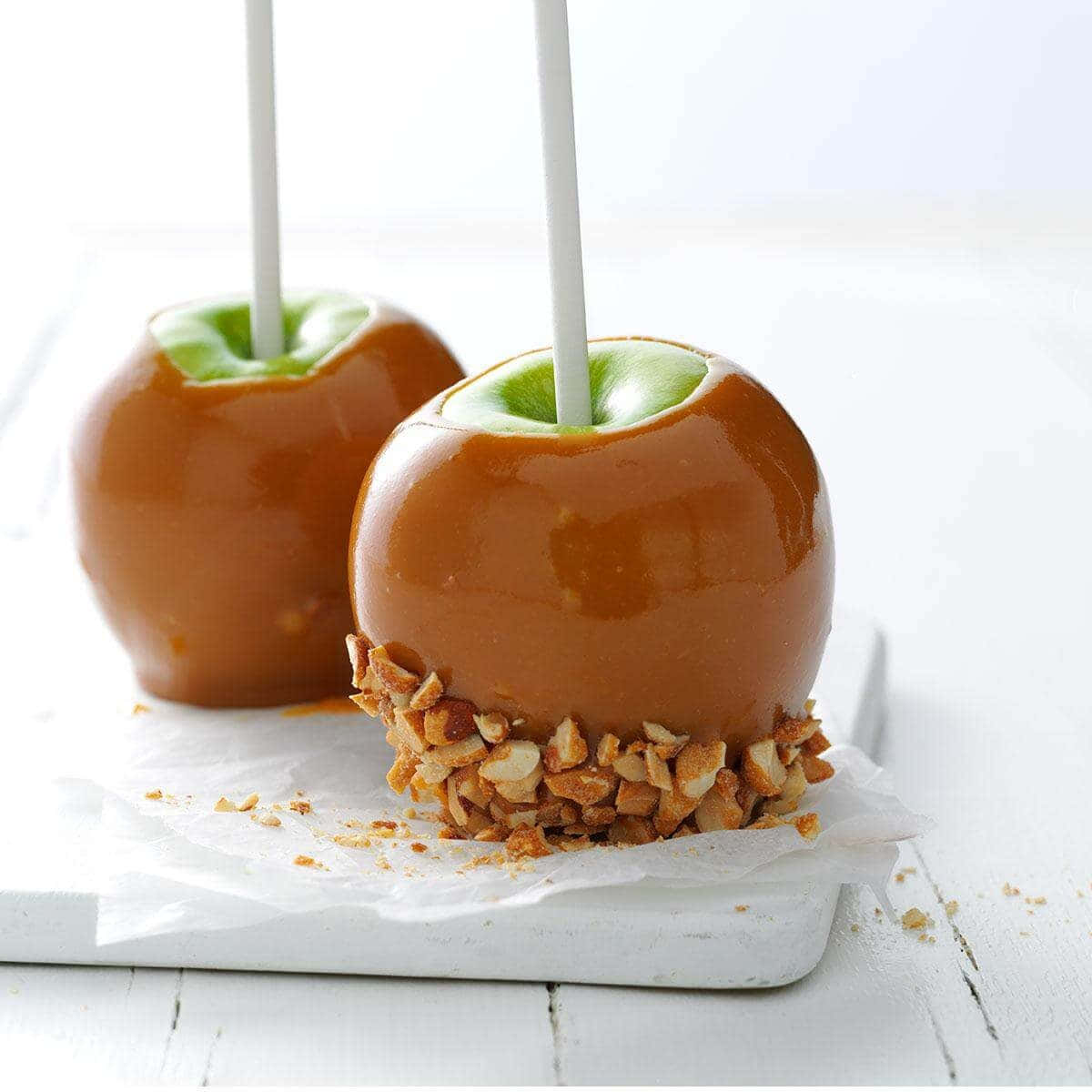 Delicious Caramel Apples on Wooden Table Wallpaper