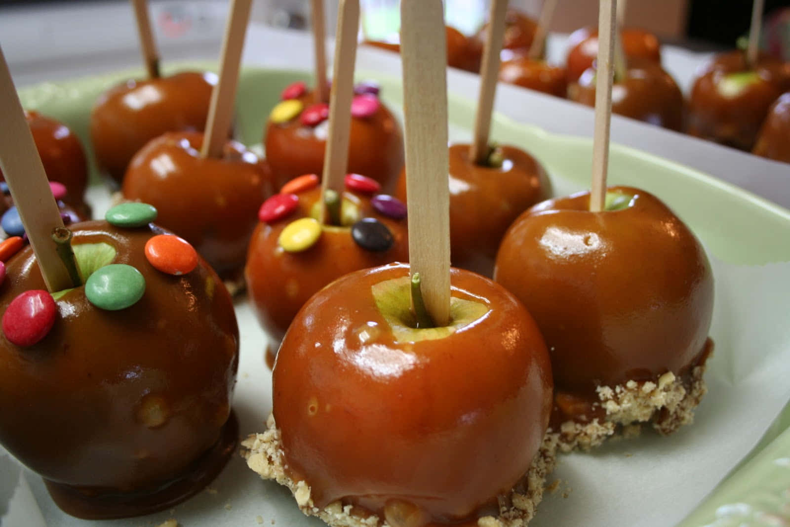 Delicious Caramel Apples on a Wooden Table Wallpaper