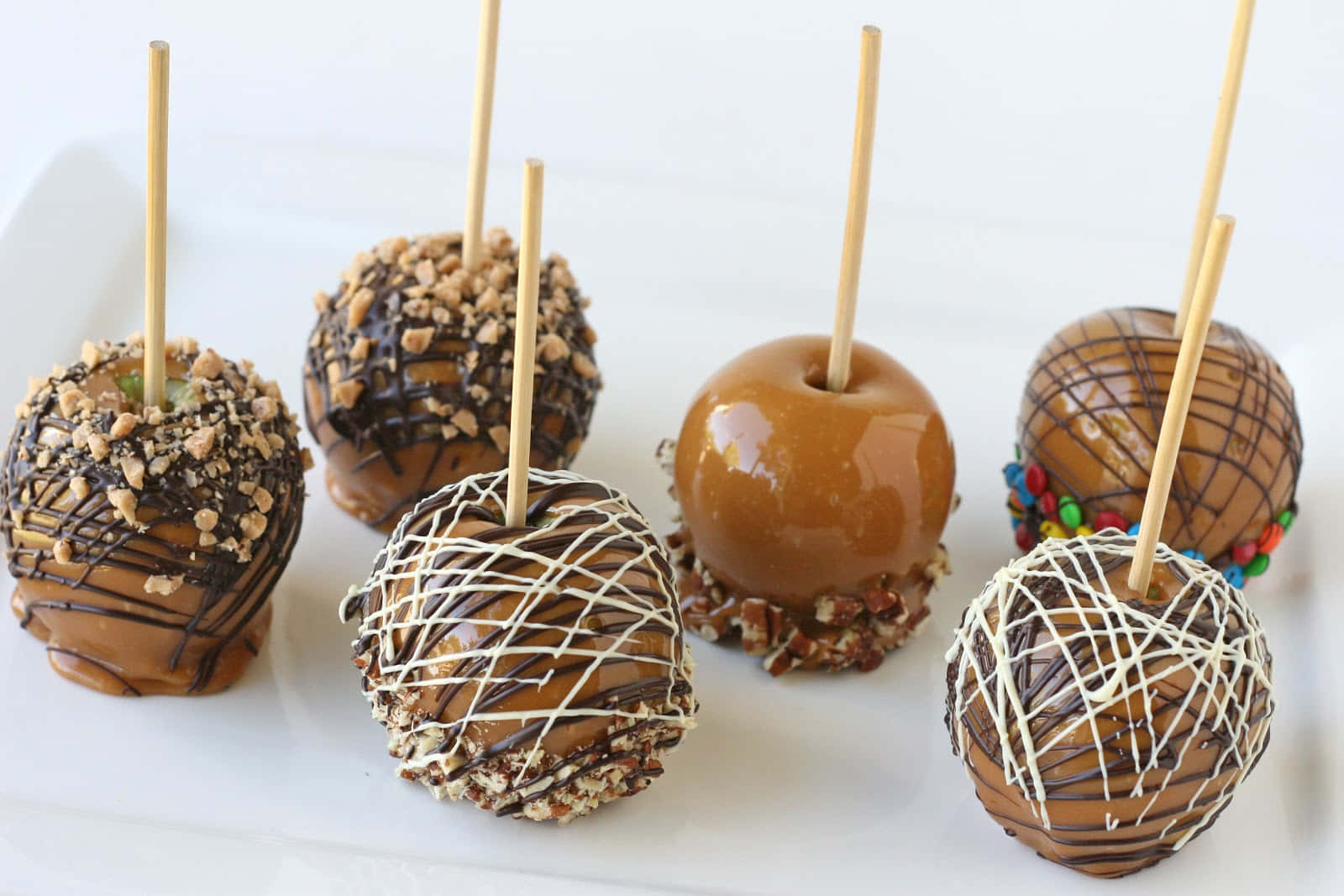 Delicious Caramel Apples with Chopped Nuts and Sprinkles Wallpaper