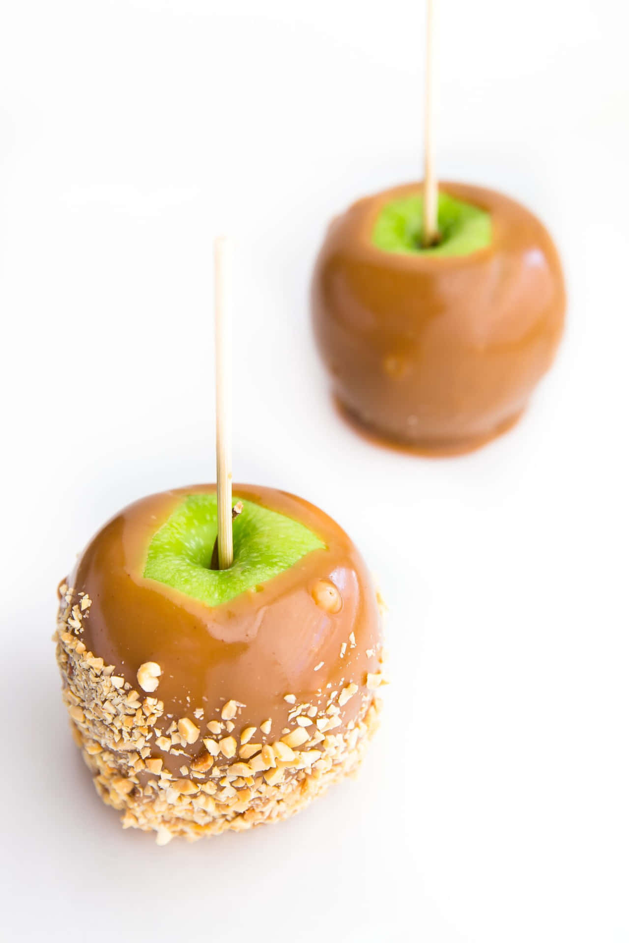 Delicious homemade caramel apples with a variety of toppings Wallpaper