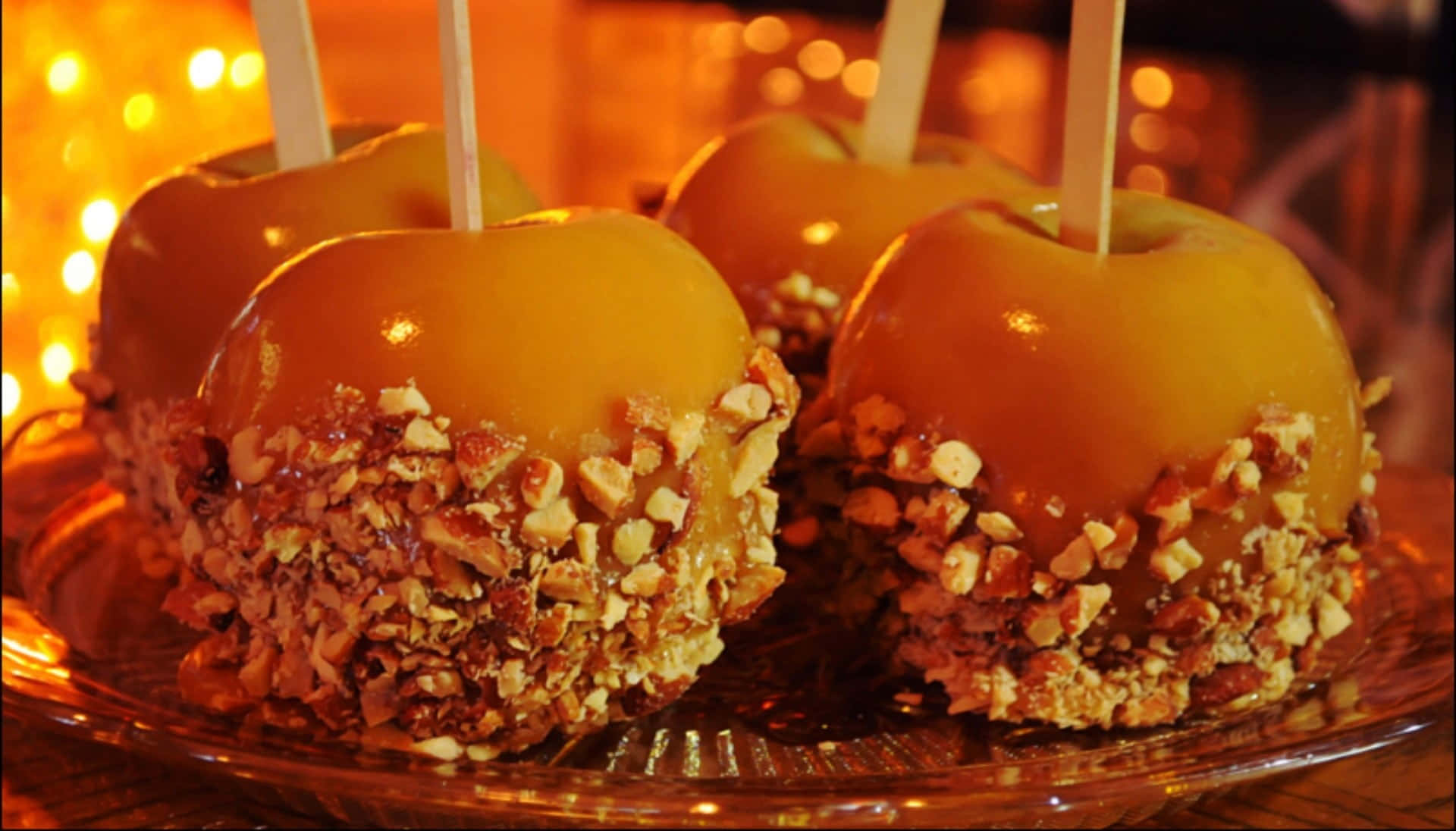 Delicious Caramel Apples on a Rustic Wooden Table Wallpaper