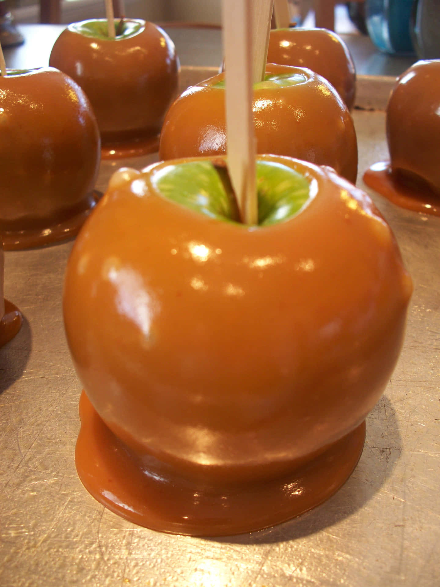 Delectable Caramel Apples on a Wood Table Wallpaper