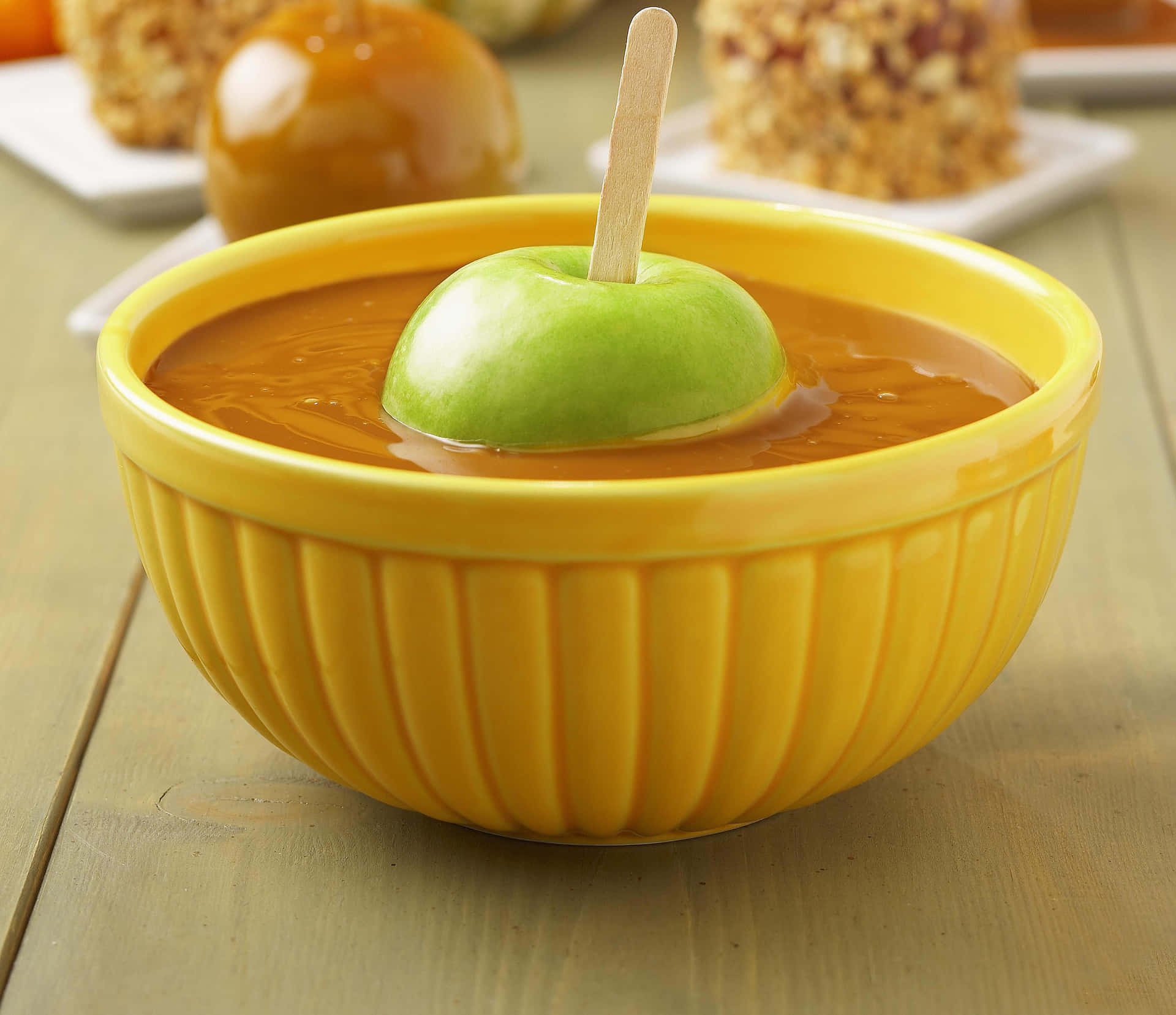 Delicious Caramel Apples on a Rustic Table Wallpaper