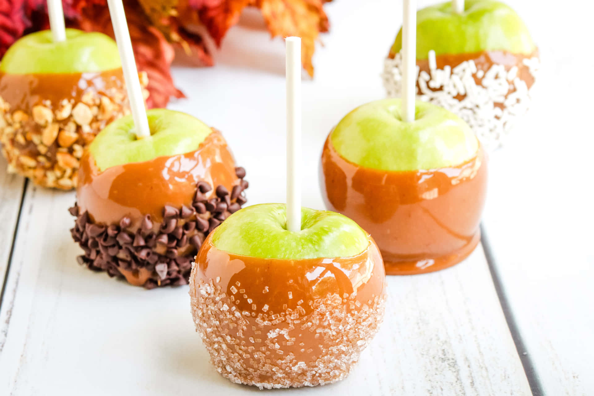 Delicious Caramel Apples on Rustic Wooden Table Wallpaper