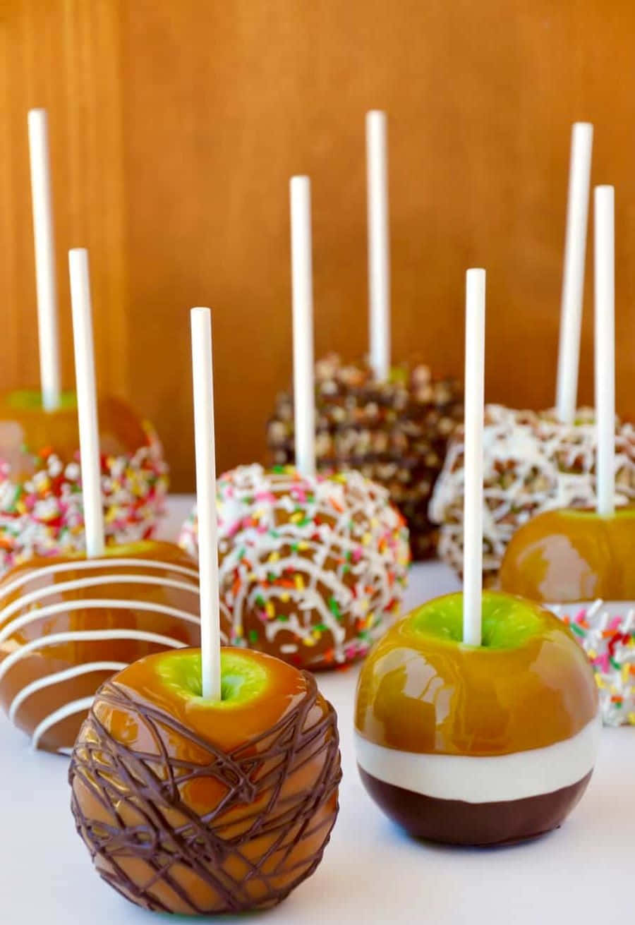 Delectable Caramel Apples on a Charming Rustic Table Wallpaper