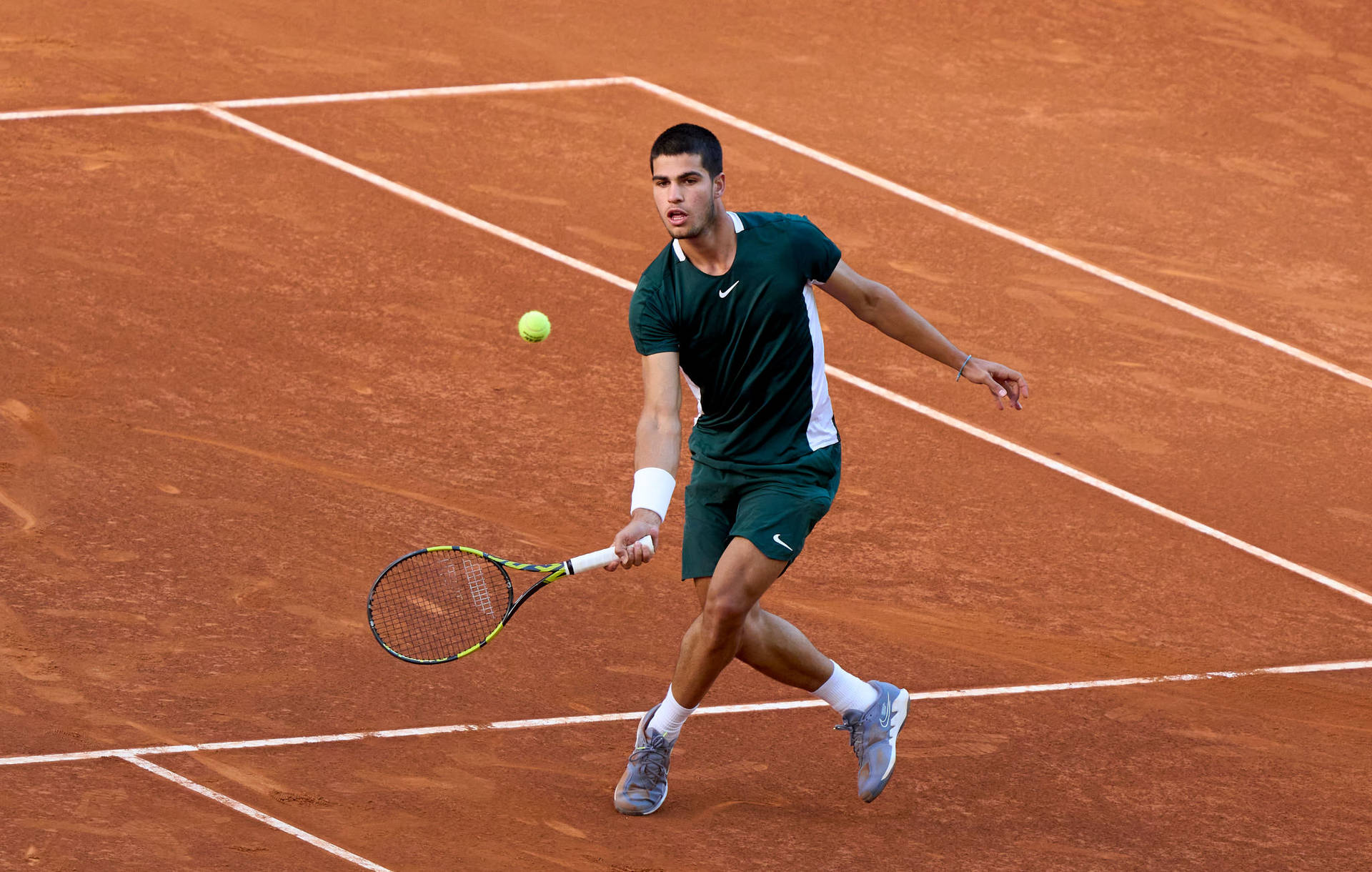 Carlos Alcaraz Chasing A Tennis Ball