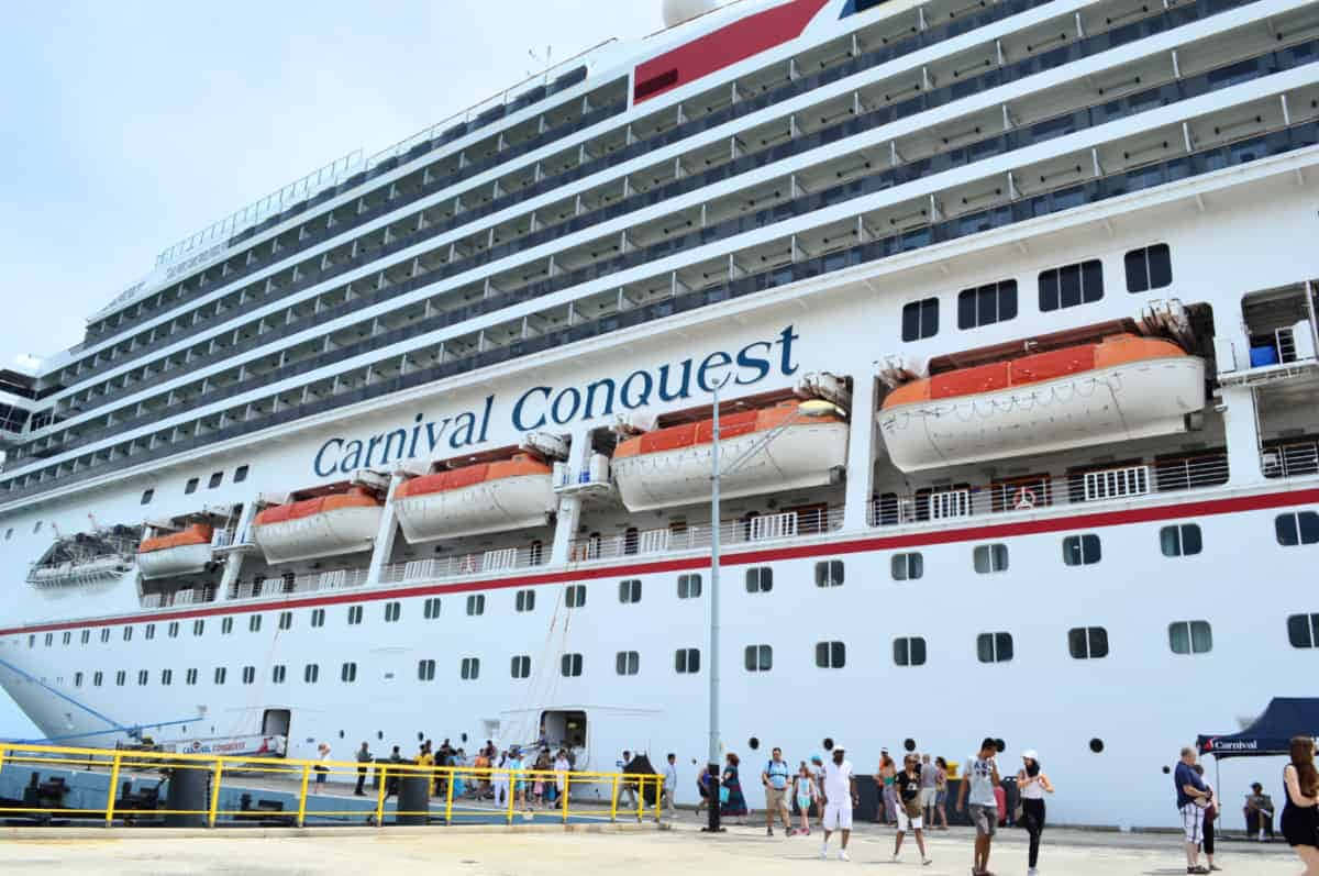 A Large Cruise Ship With People Standing Outside